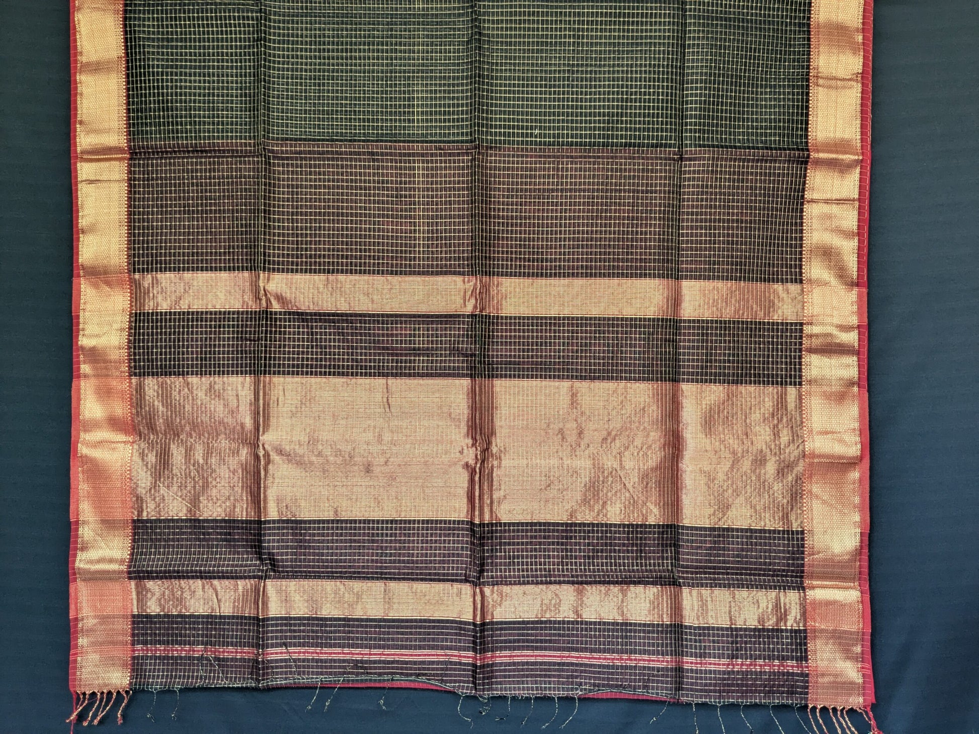 Detailed image of zari-checked pallu reflecting traditional craftsmanship in shimmering gold thread.