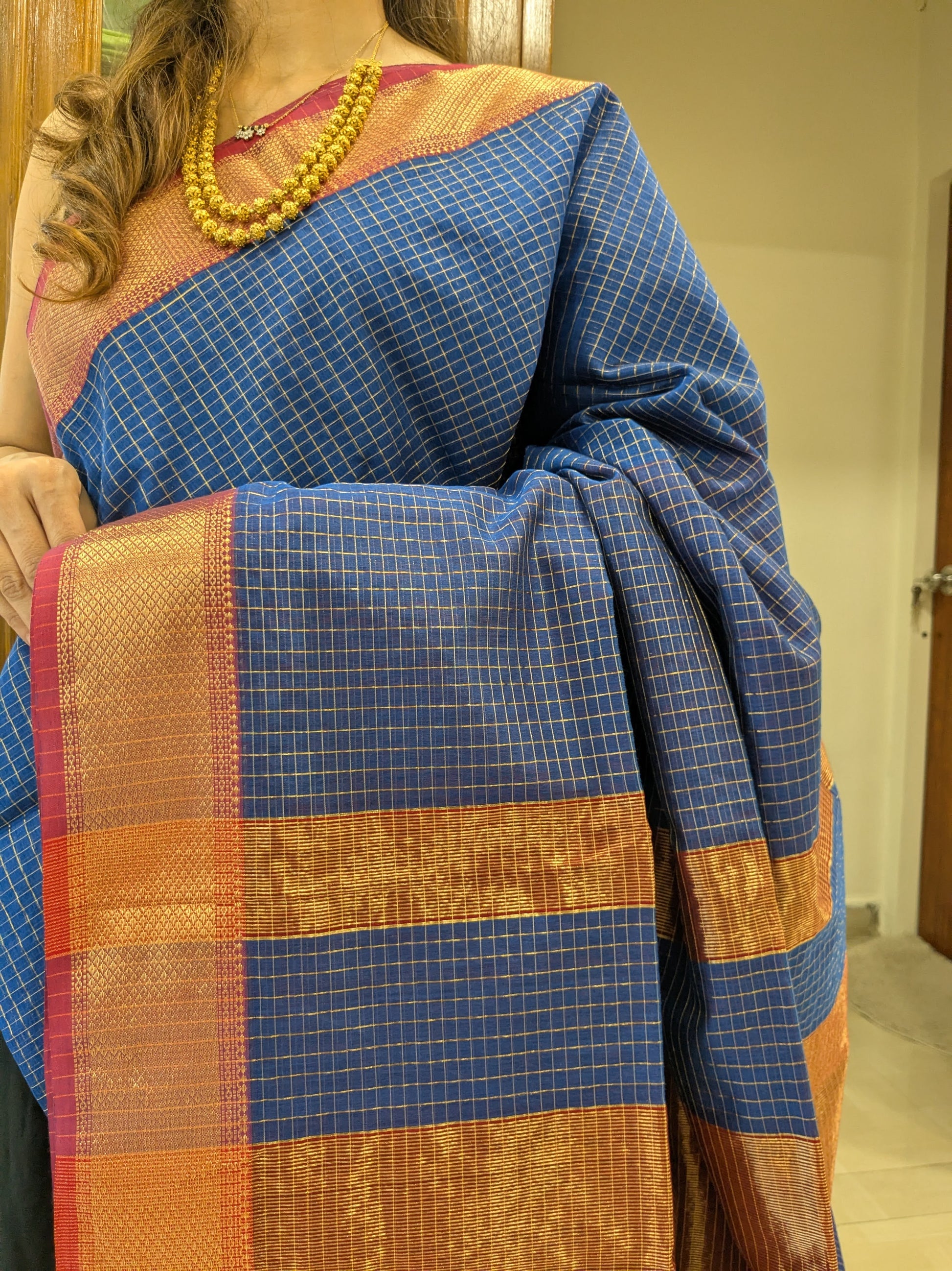 Close-up of grey Maheshwari silk-cotton saree with zari checks, medium border