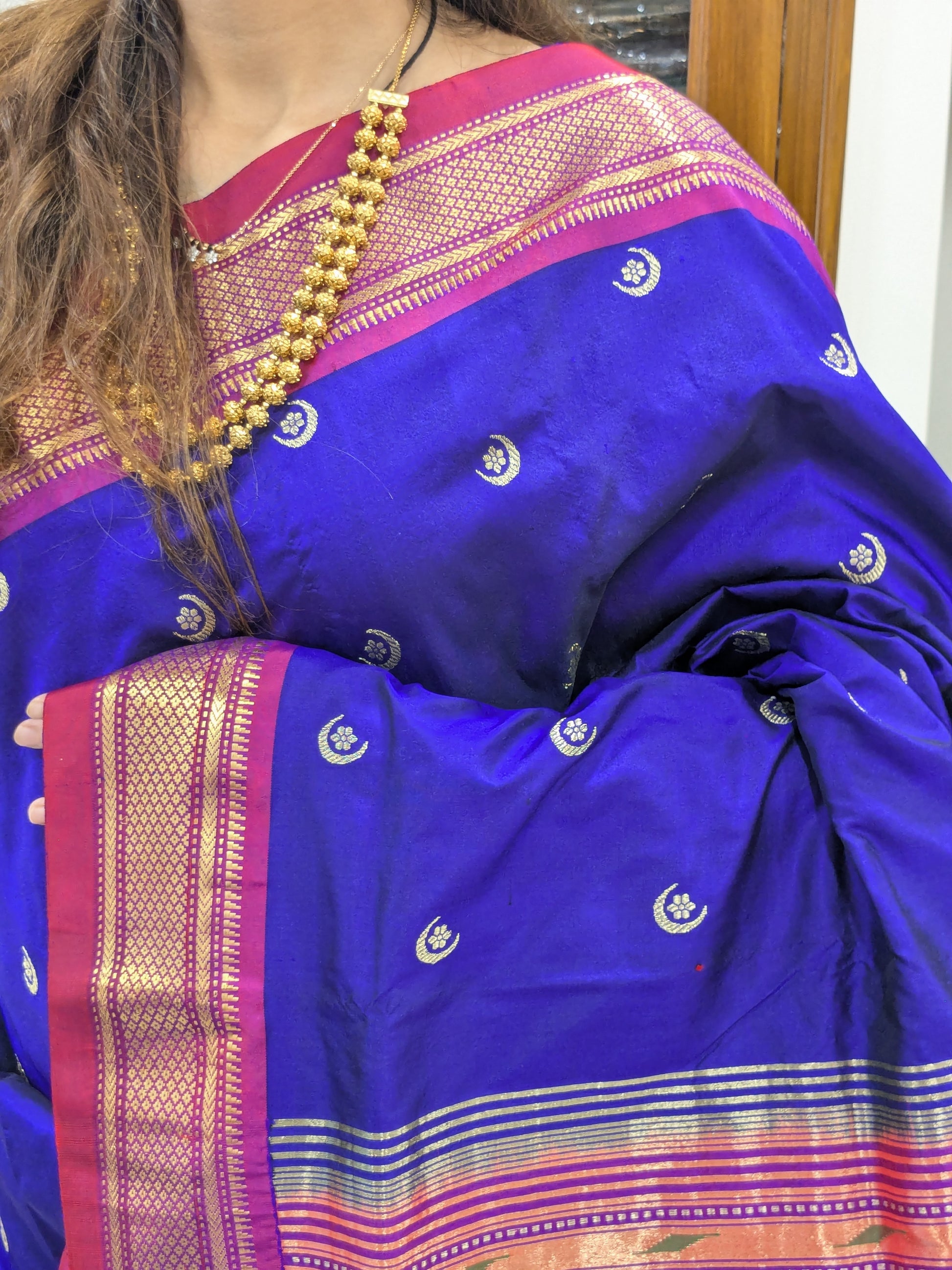 Close-up of bluish-purple pure silk Paithani with moon and flower butti and Narali border.