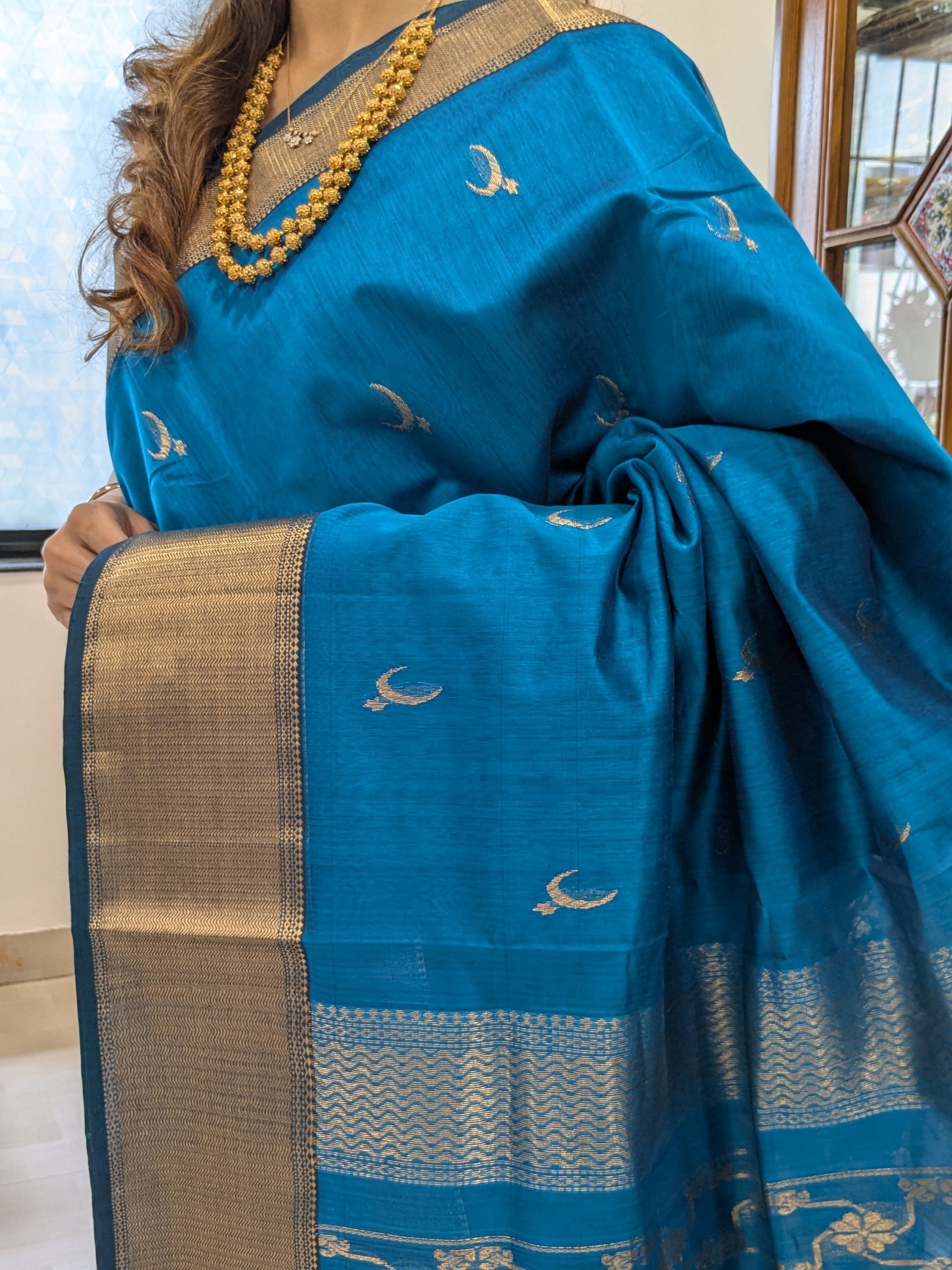Close-up of Fresh Blue Maheshwari saree with moon-flower motifs and jaali pallu transition.