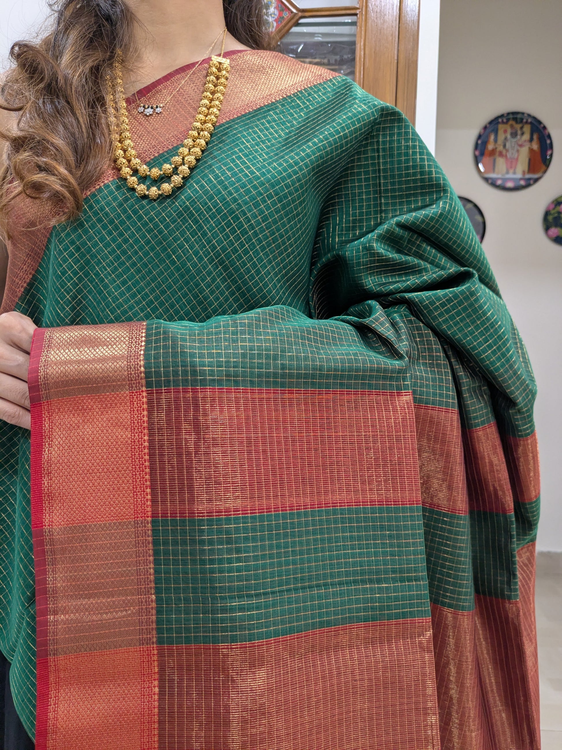 Close-up of fresh green Maheshwari silk-cotton saree with zari checks, medium border