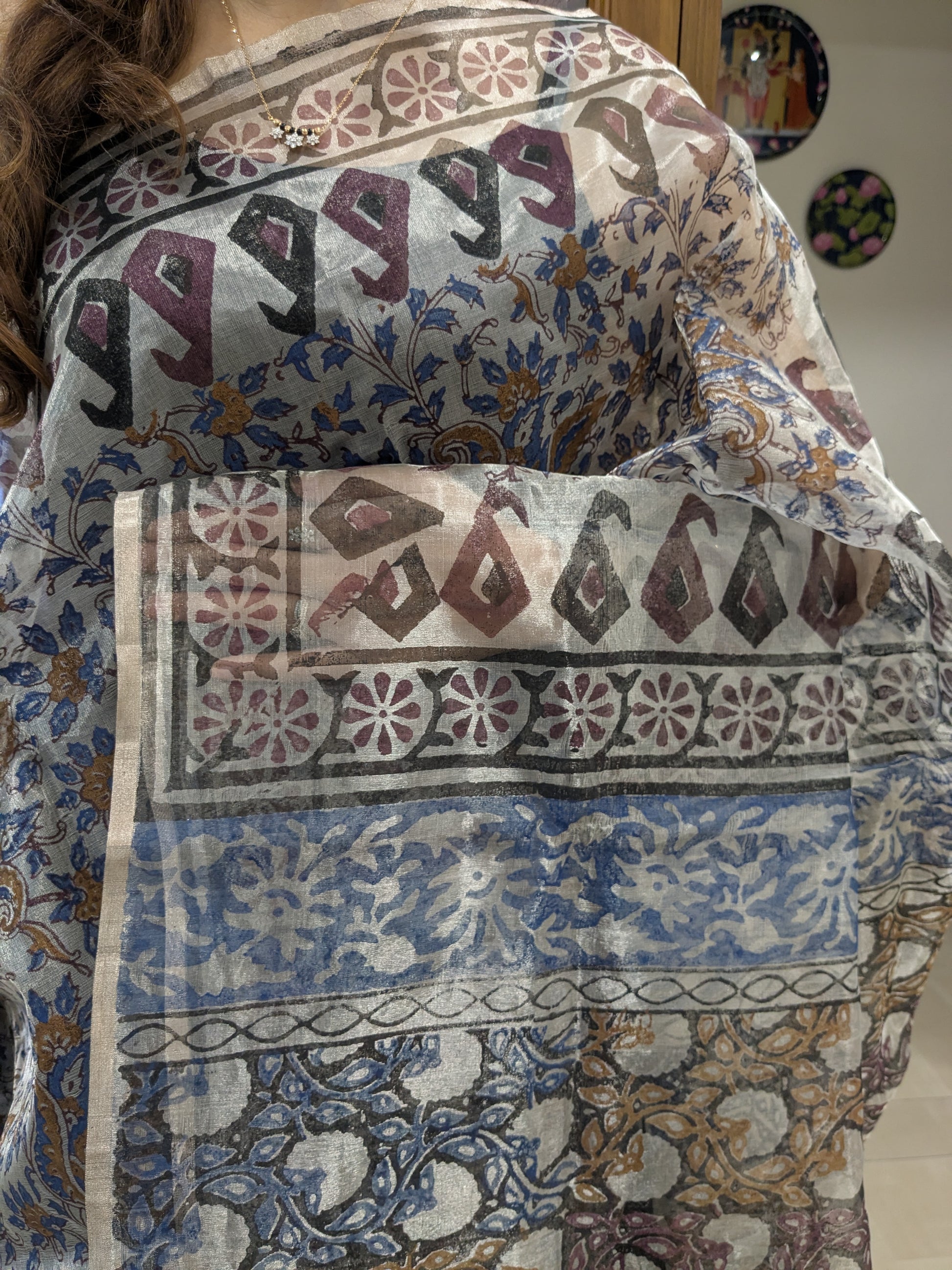 Close-up of blue and black Chanderi silk saree with delicate hand block printed floral motifs.