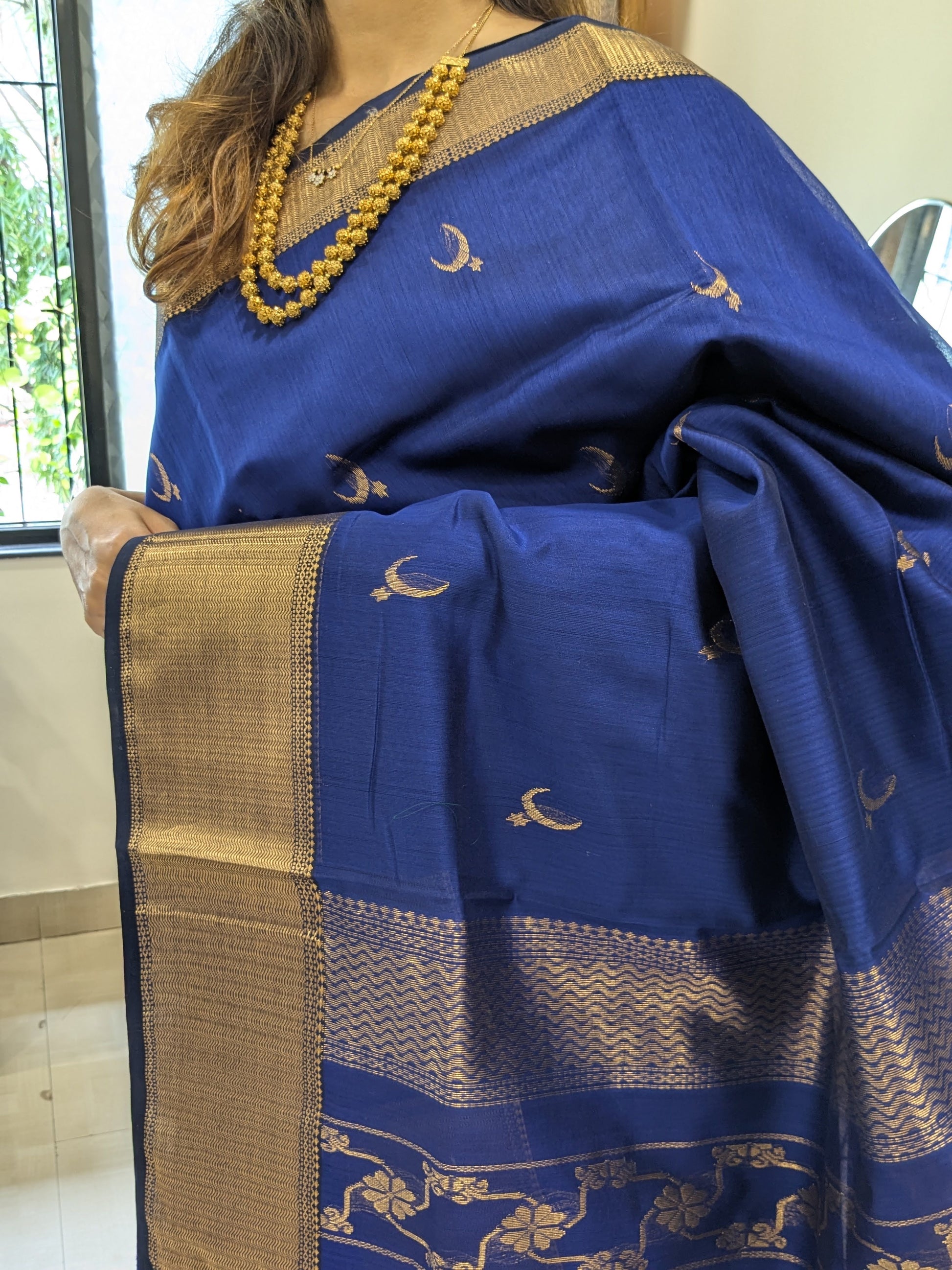 Close-up of Royal Blue Maheshwari saree with moon-flower motifs and ornate jaali pallu transition.