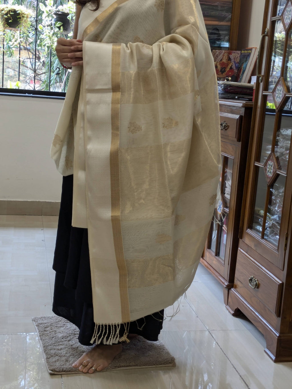 Detailed image of zari-lined pallu with subtle gold shimmer and delicate flower accents.