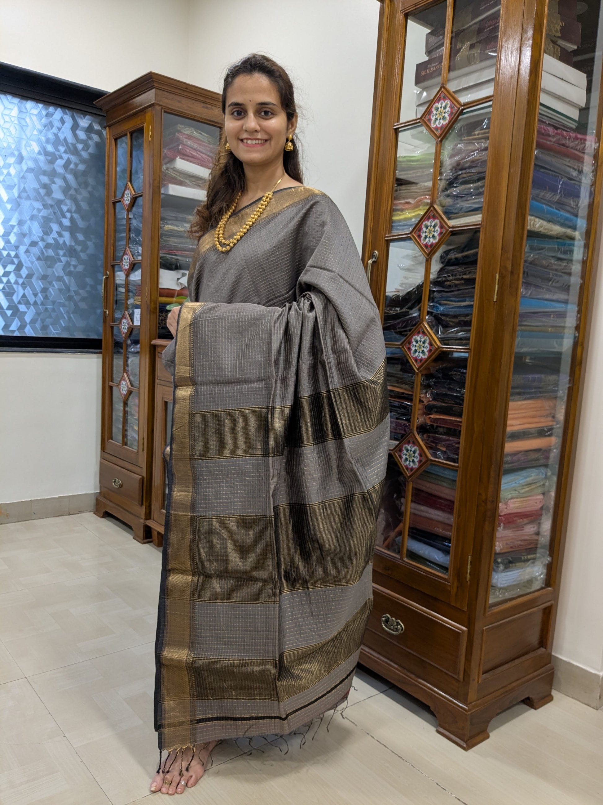 Full front view of elegant grey Maheshwari saree with festive zari detailing and classic silhouette.