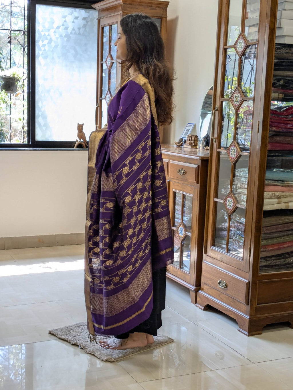 Side view of handloom purple saree highlighting graceful drape, intricate weave, and elegant border design. 