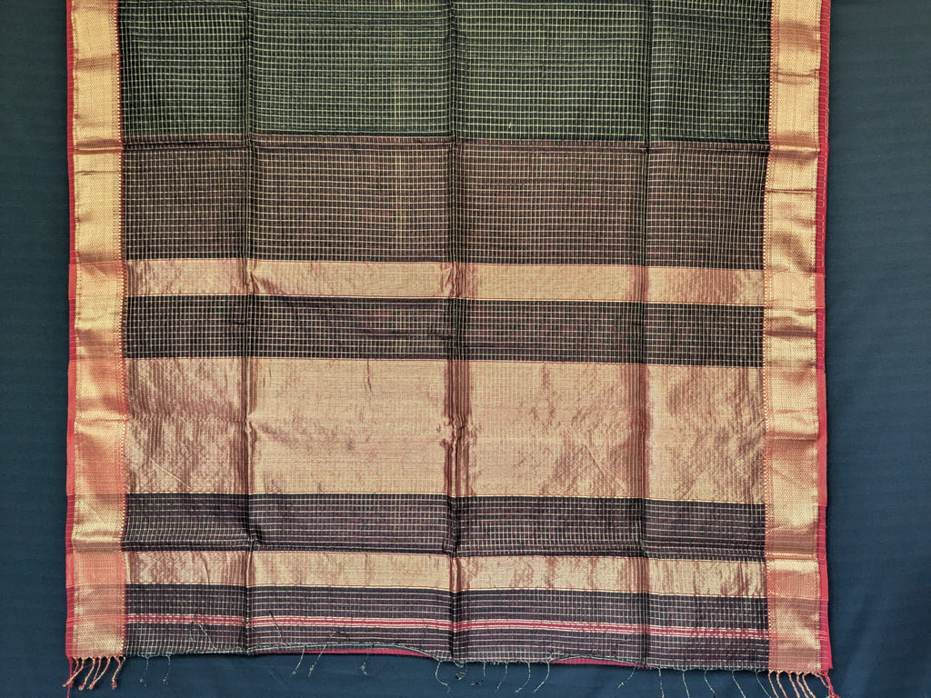 Detailed image of zari-checked pallu reflecting traditional craftsmanship in shimmering gold thread.  