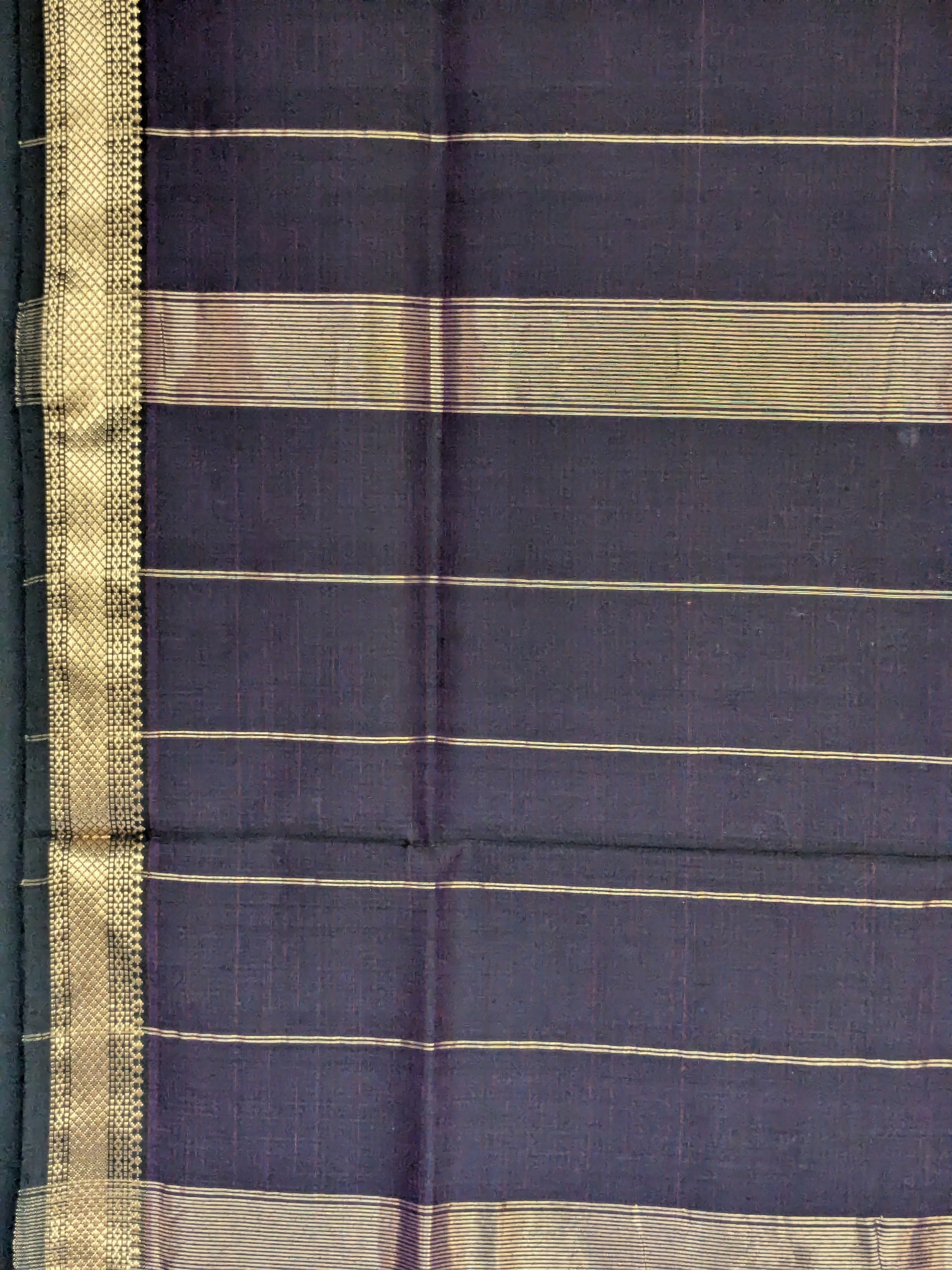 Detailed image of zari-lined pallu with clean striped patterns and delicate gold accents.  