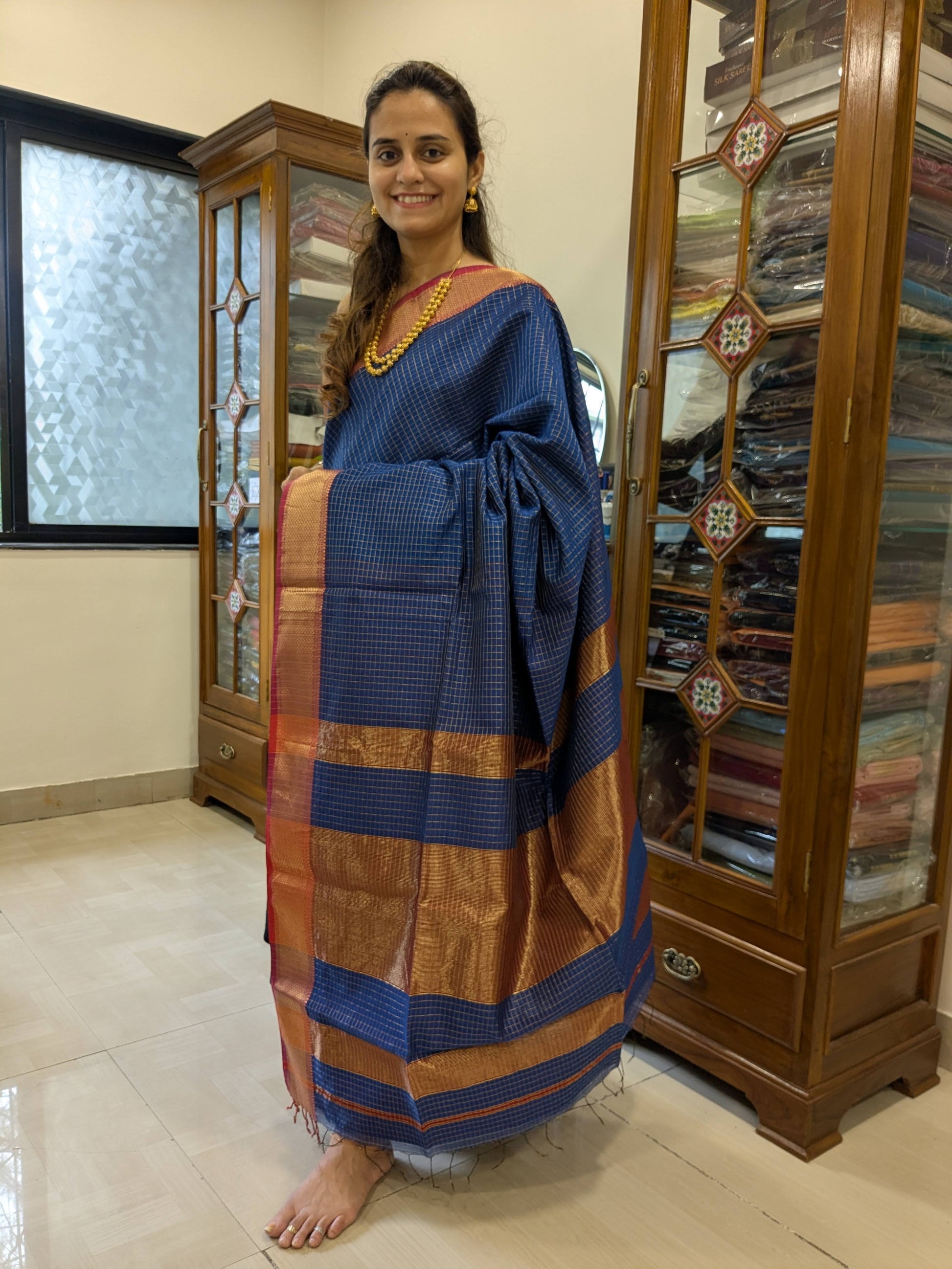 Full front view of festive grey handloom Maheshwari saree featuring golden zari check detailing and smooth finish.