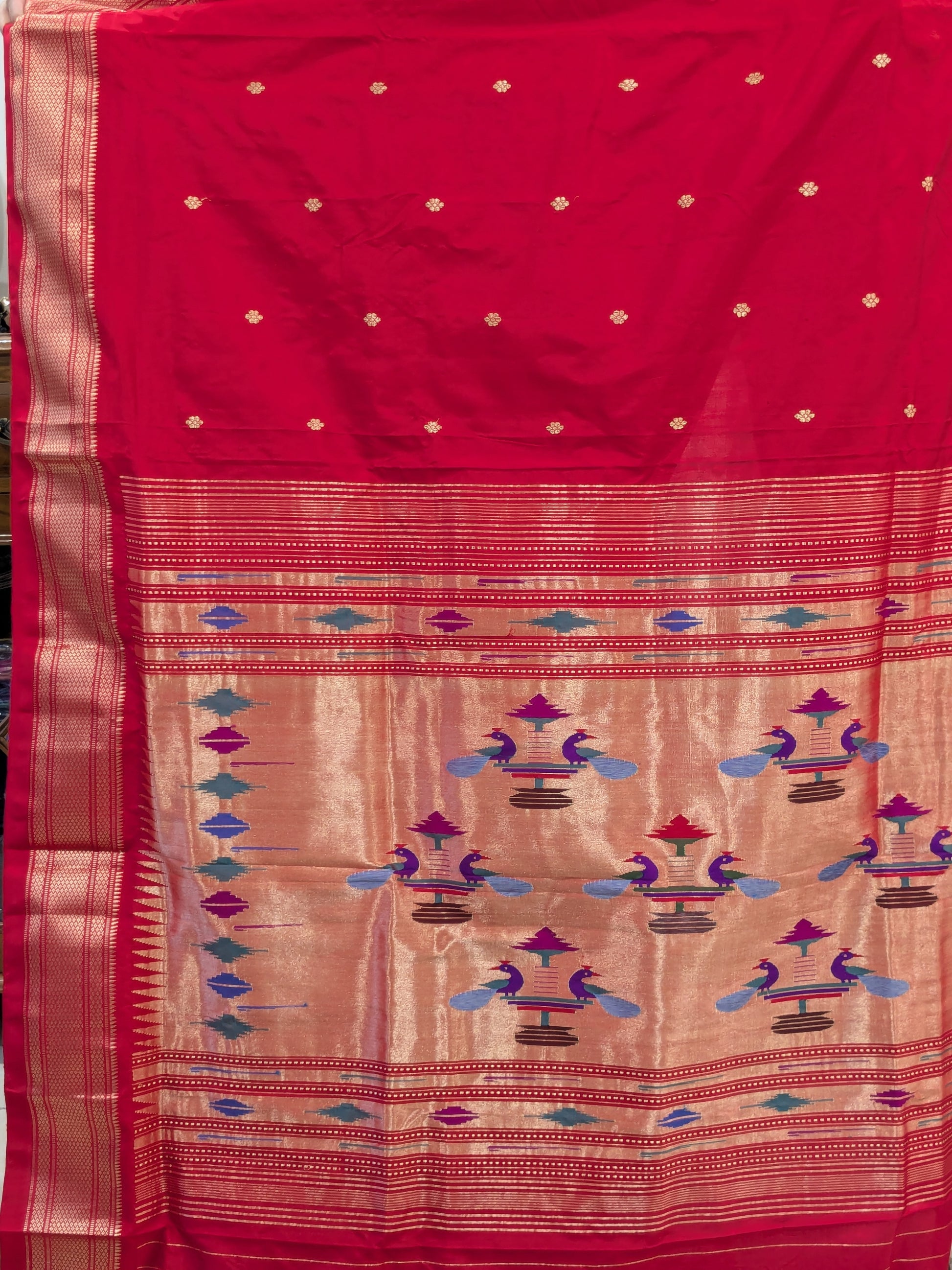 Detailed shot of the pallu design with traditional floral patterns and shimmering silk texture.