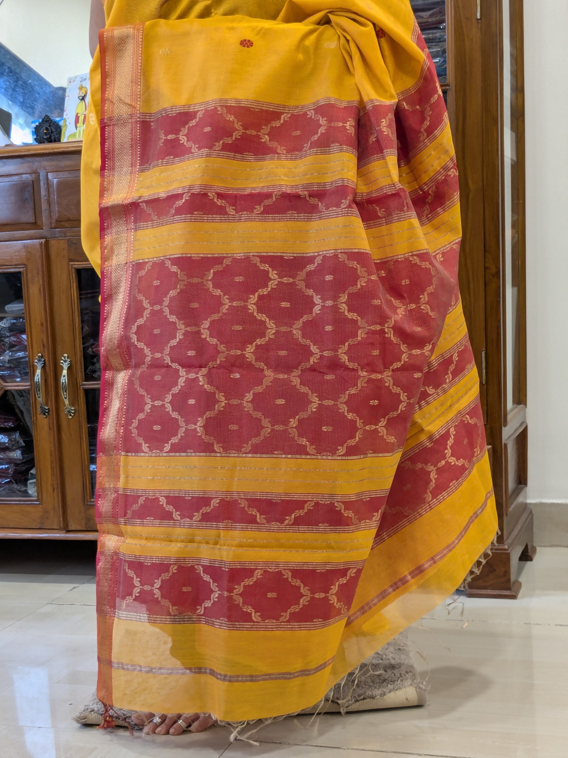 Intricate jaali pallu in yellow silk tissue with traditional craftsmanship.