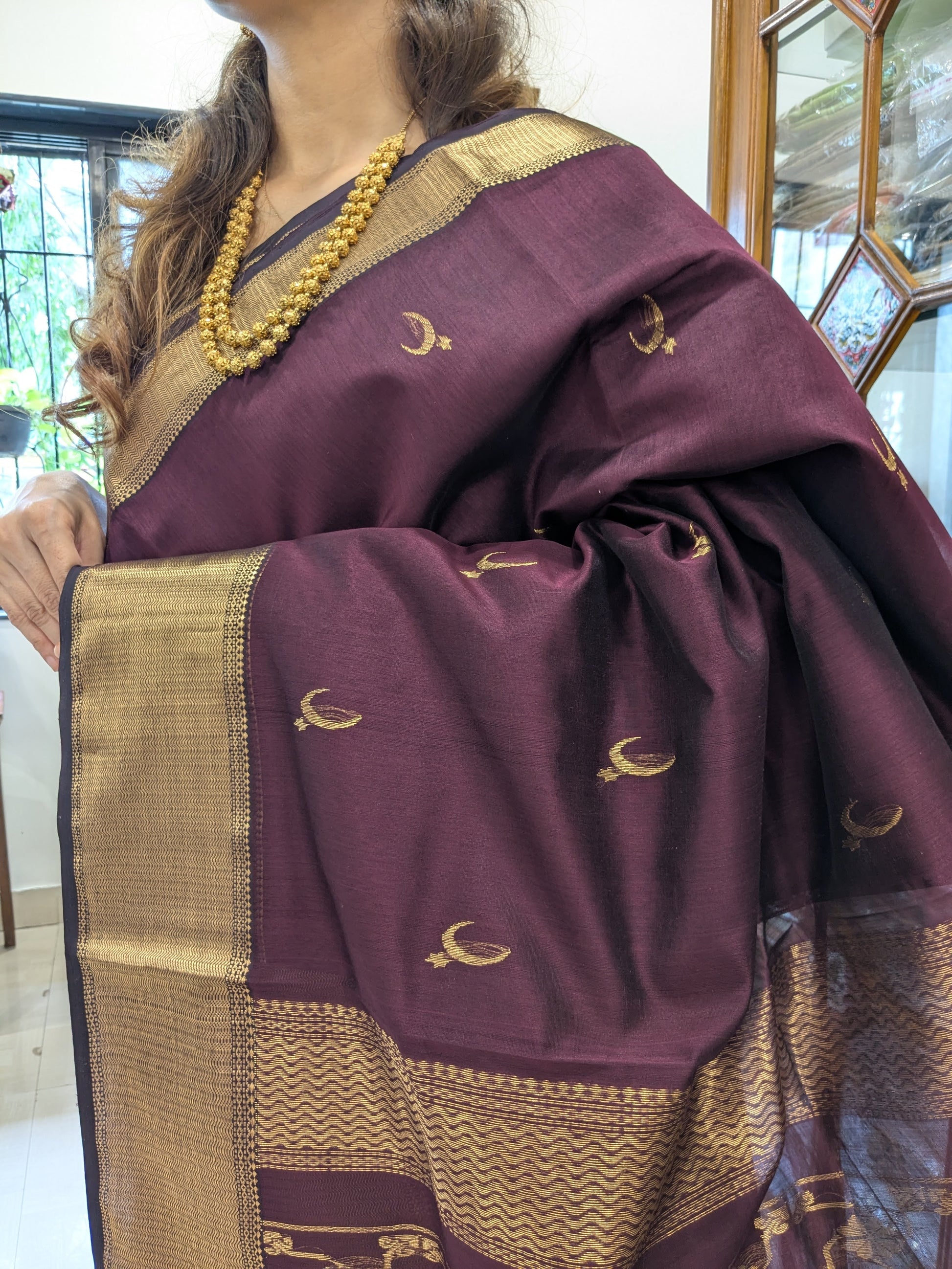 Close-up of Brown Maheshwari saree with moon-flower motifs and jaali pallu craftsmanship.