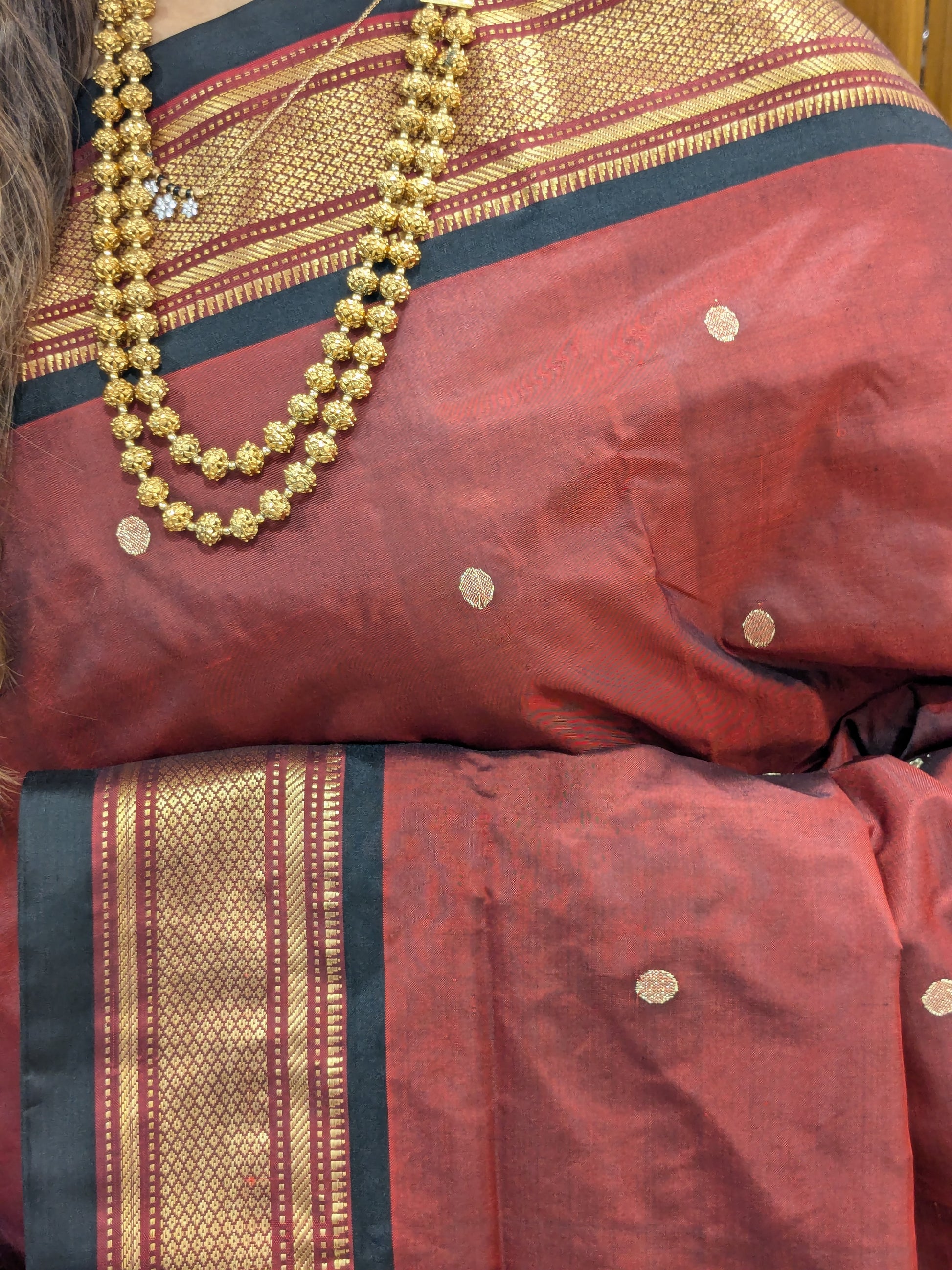 Close-up of brown pure silk Paithani saree with coin butti motifs, handwoven with a traditional narali border.