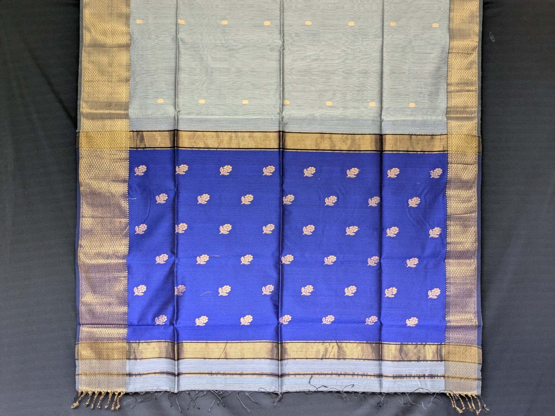 Detailed image of blue buttidar pallu with traditional flower motifs and shimmering handwoven texture. 