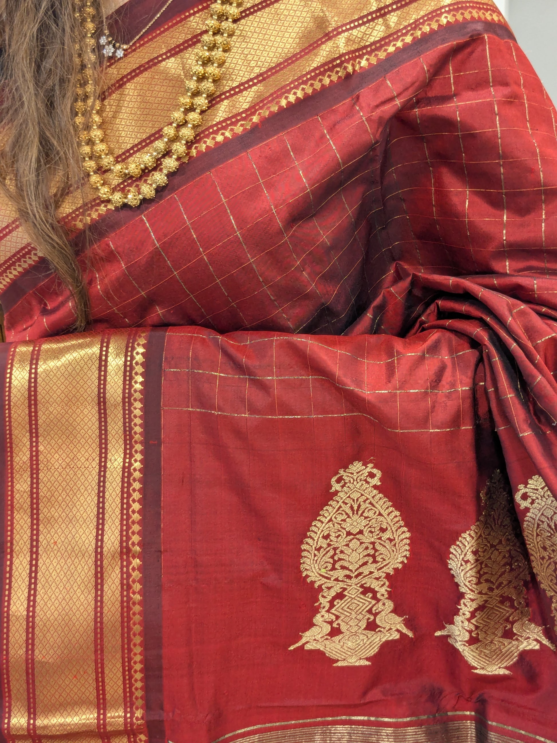Close-up of red-brown pure silk Paithani with shimmering zari checks and ornate Narali border.