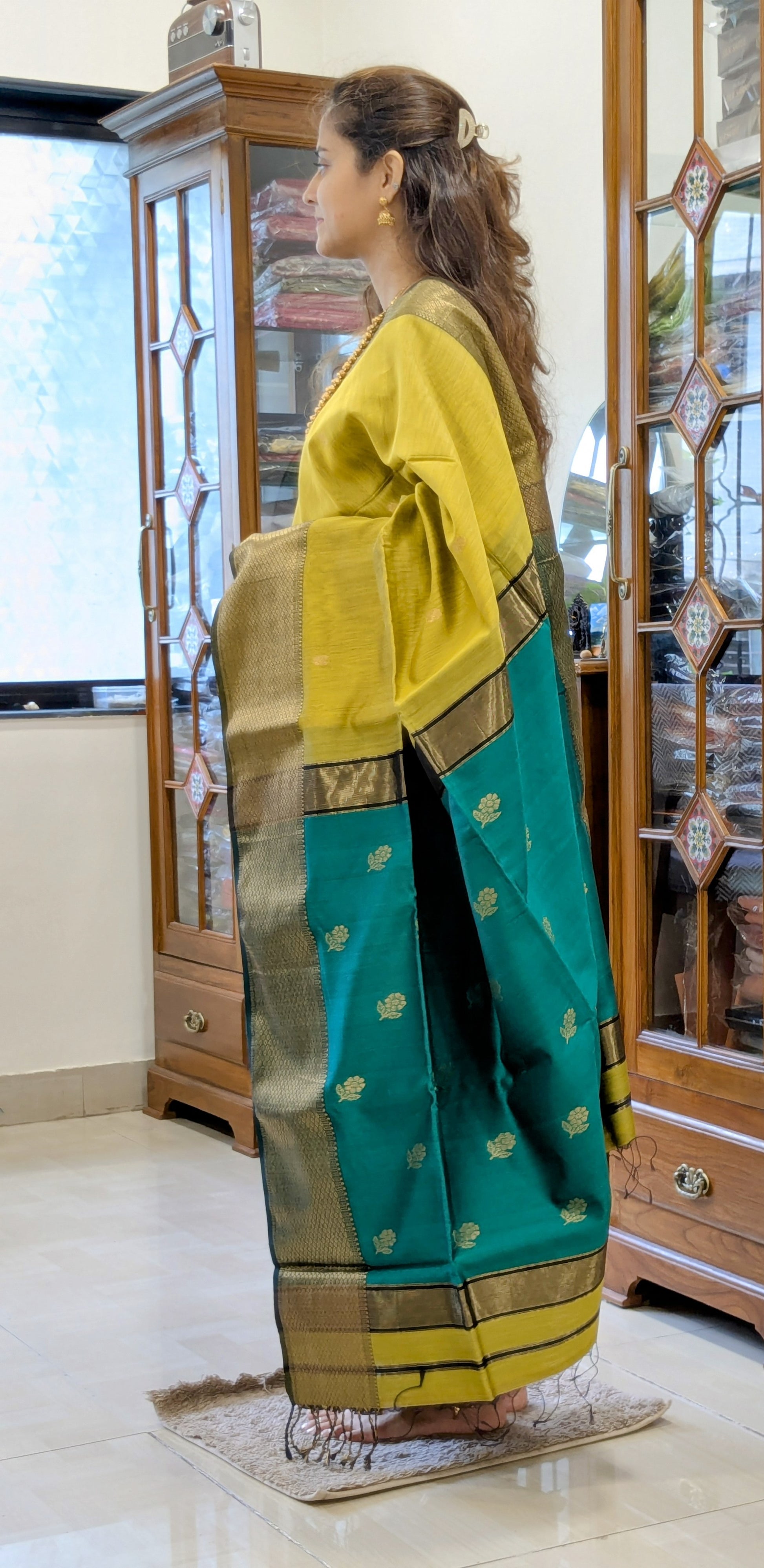 Side view of mehendi green saree showing smooth drape, handwoven texture, and elegant color contrast.