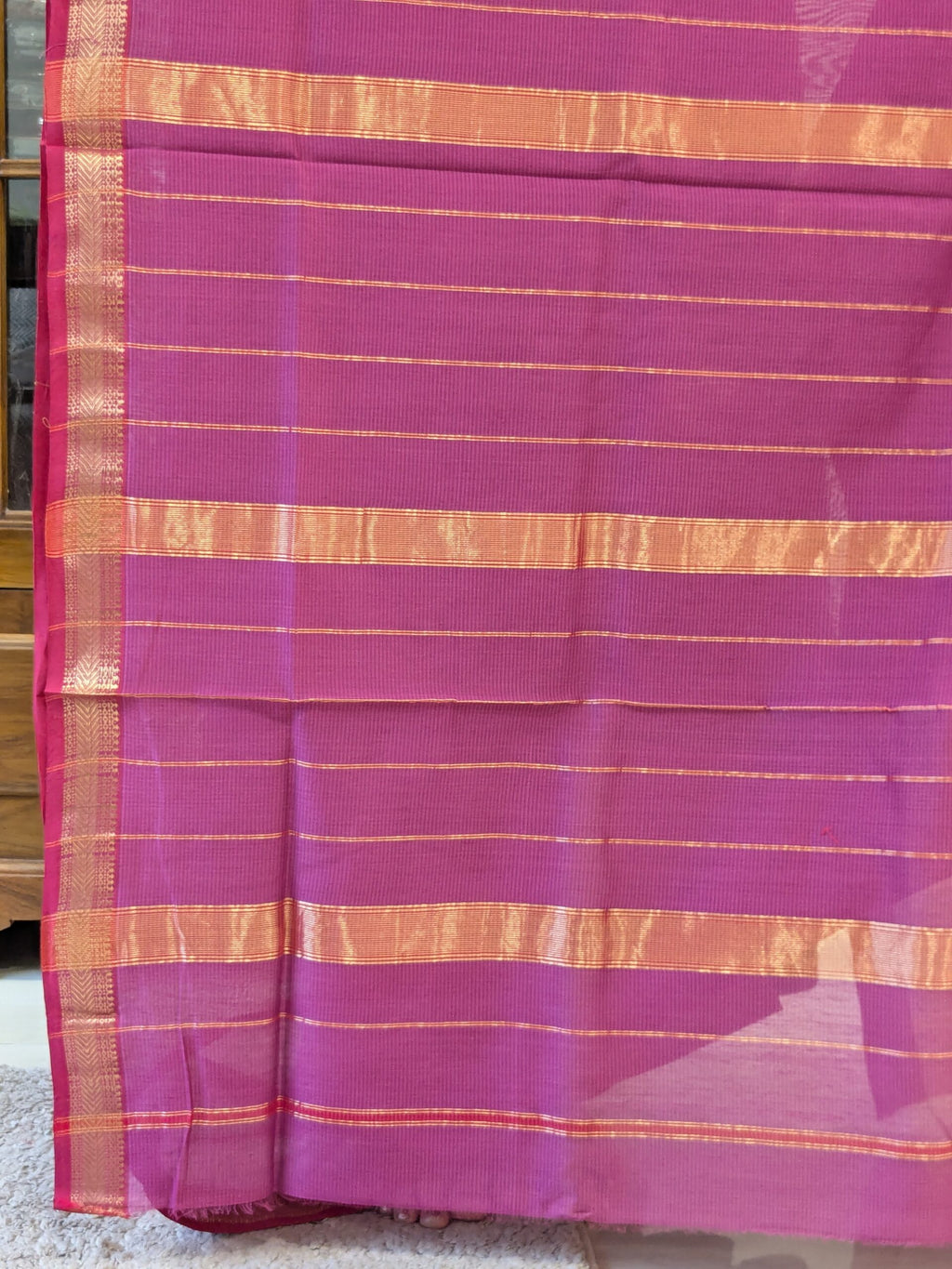 Detailed image of zari-lined pallu with delicate golden stripes and understated traditional charm.