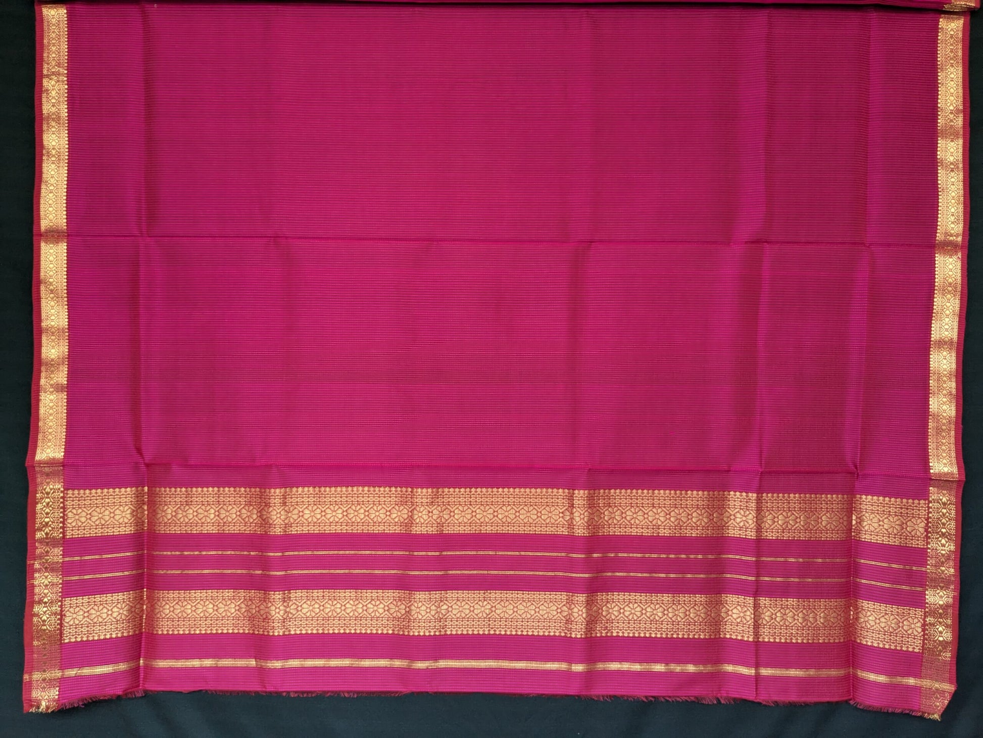 Close-up of hot pink Maheshwari saree with small checks, vintage-style pallu, and small zari border in silk-cotton blend.
