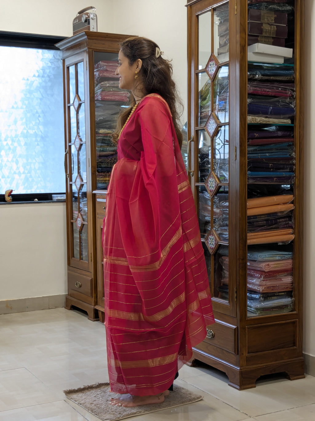  Side view of rani pink saree showing graceful drape, soft silk-cotton texture, and traditional weave. 