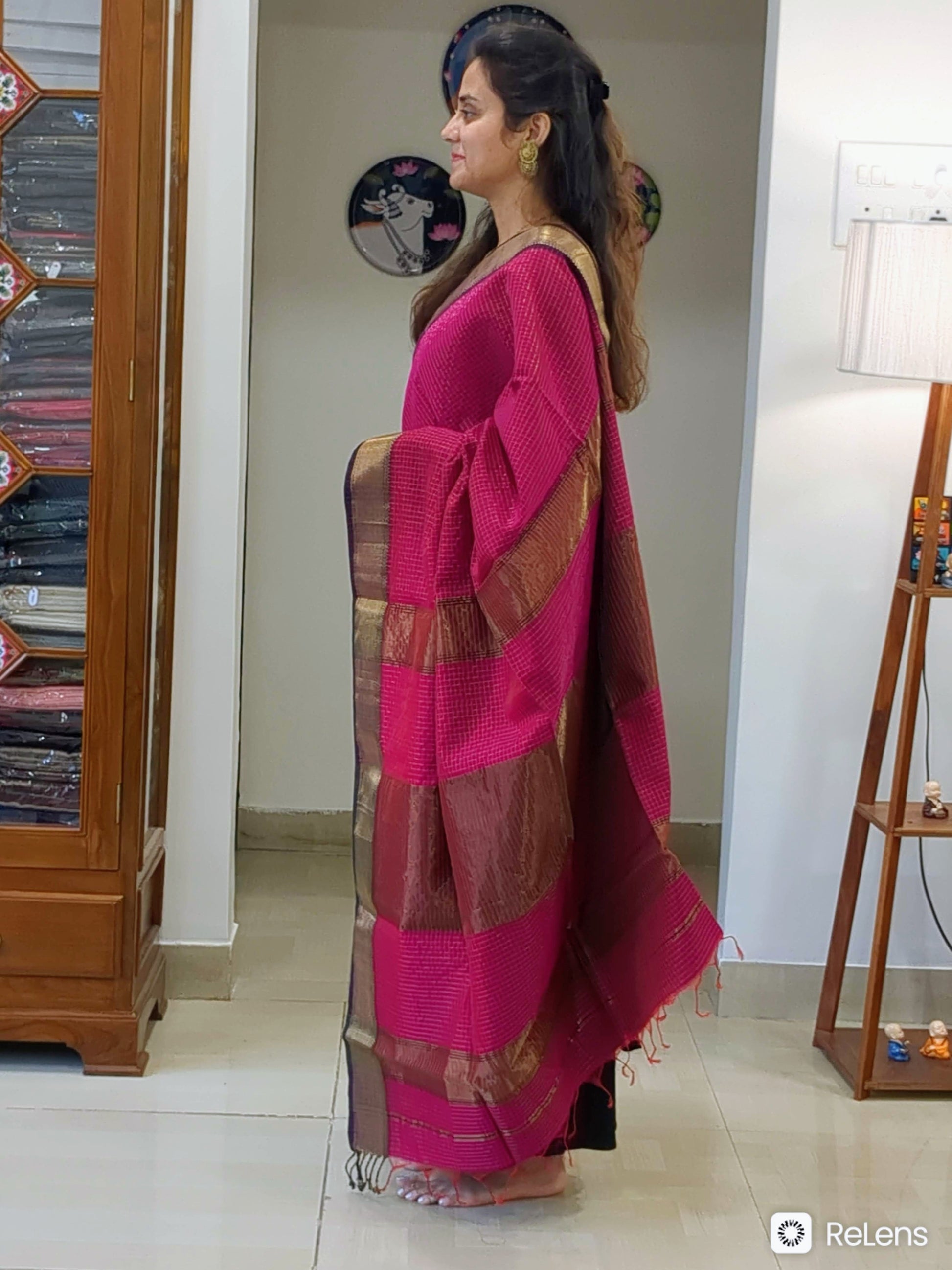 Side view of dark rani pink saree showing rich drape, handwoven finish, and intricate golden check pattern. 