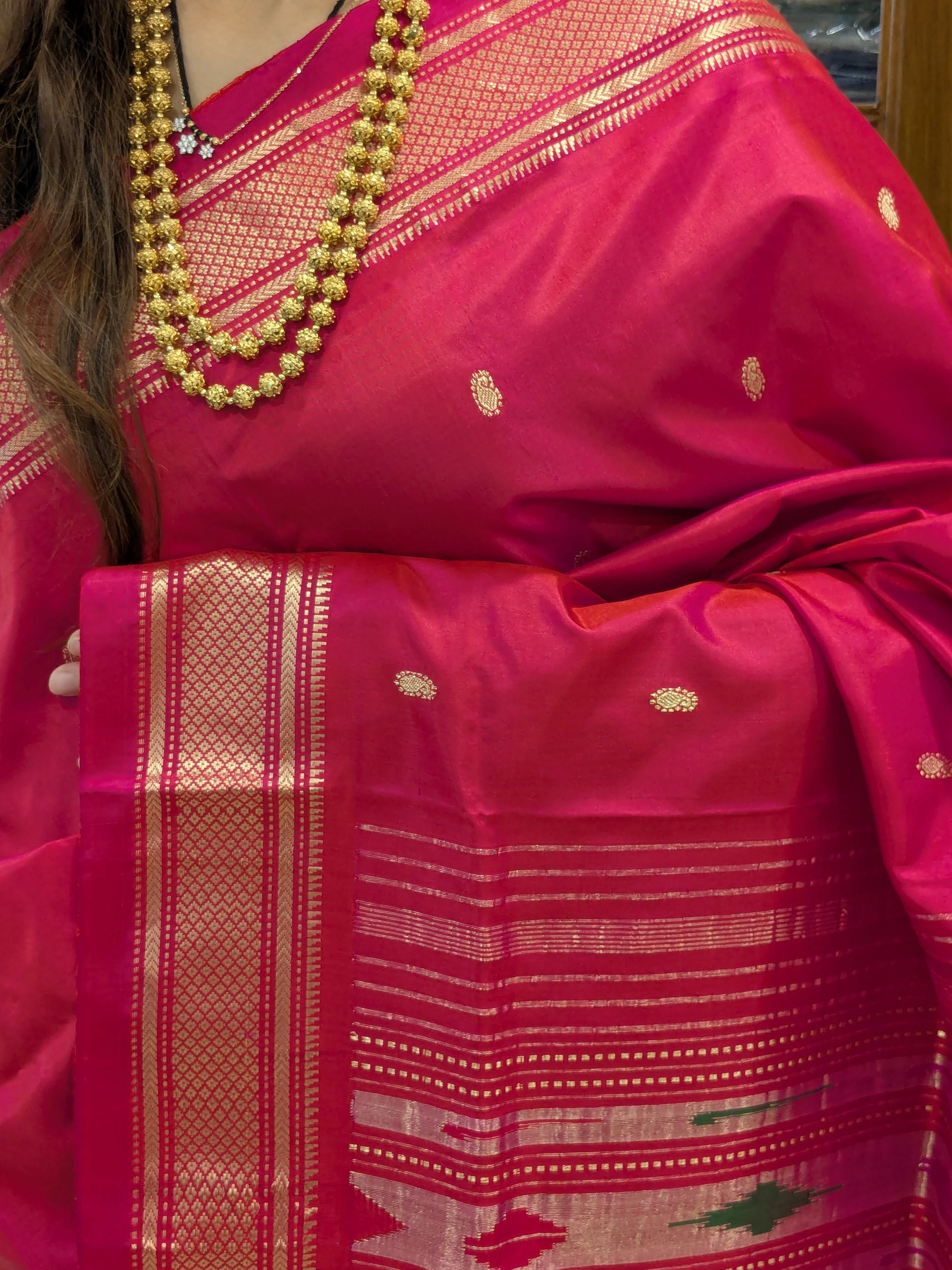 Close-up of the fuchsia pink Paithani saree with intricate Koyri motifs and iconic peacock pallu.