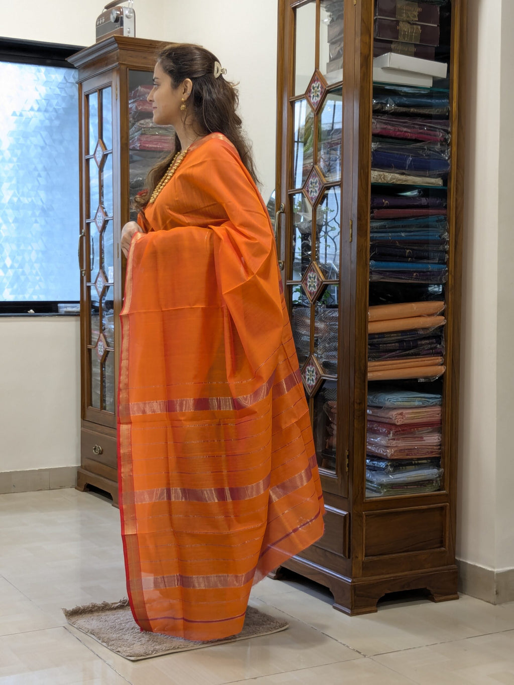  Side view of rust orange saree showing smooth drape, rich silk-cotton texture, and traditional weave. 