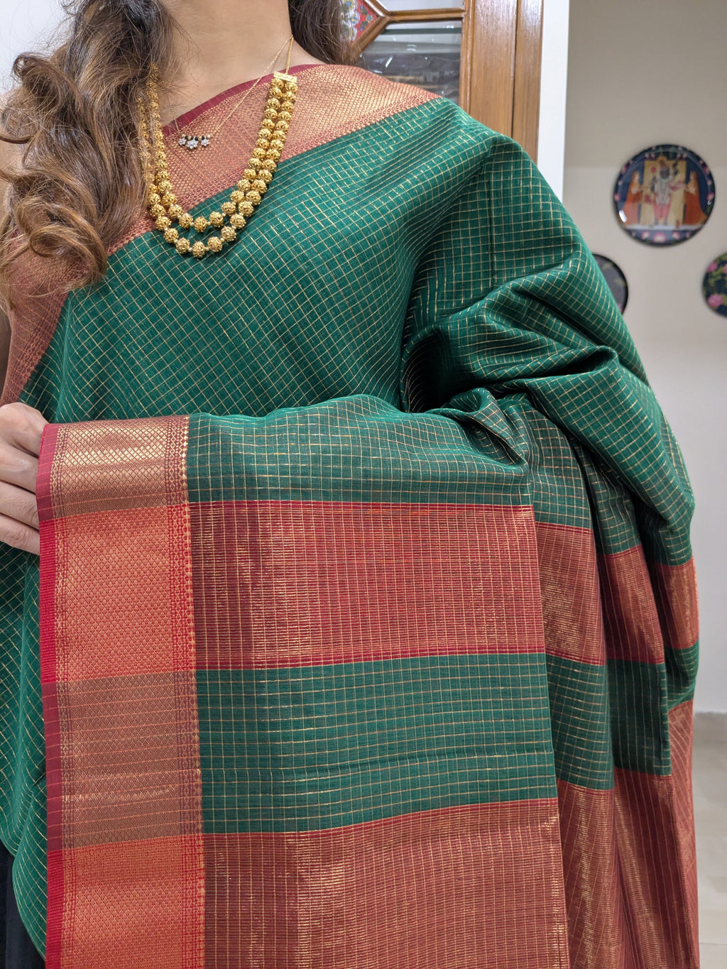 Close-up of fresh green Maheshwari silk-cotton saree with zari checks, medium border