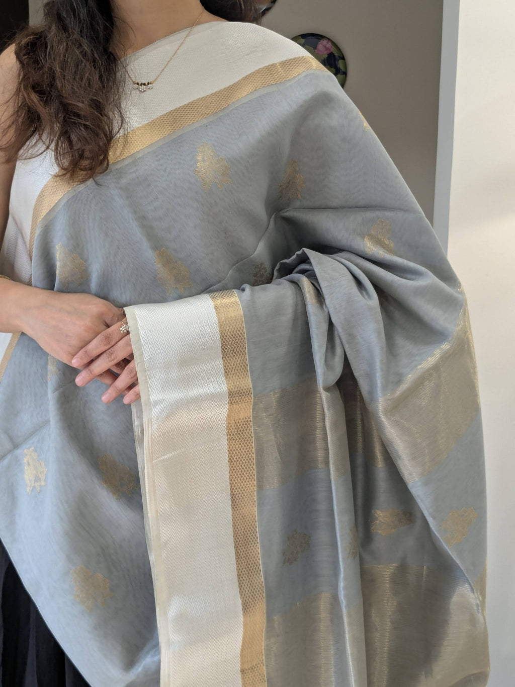 Close-up of grey Maheshwari silk cotton saree with flower motifs, white resham border