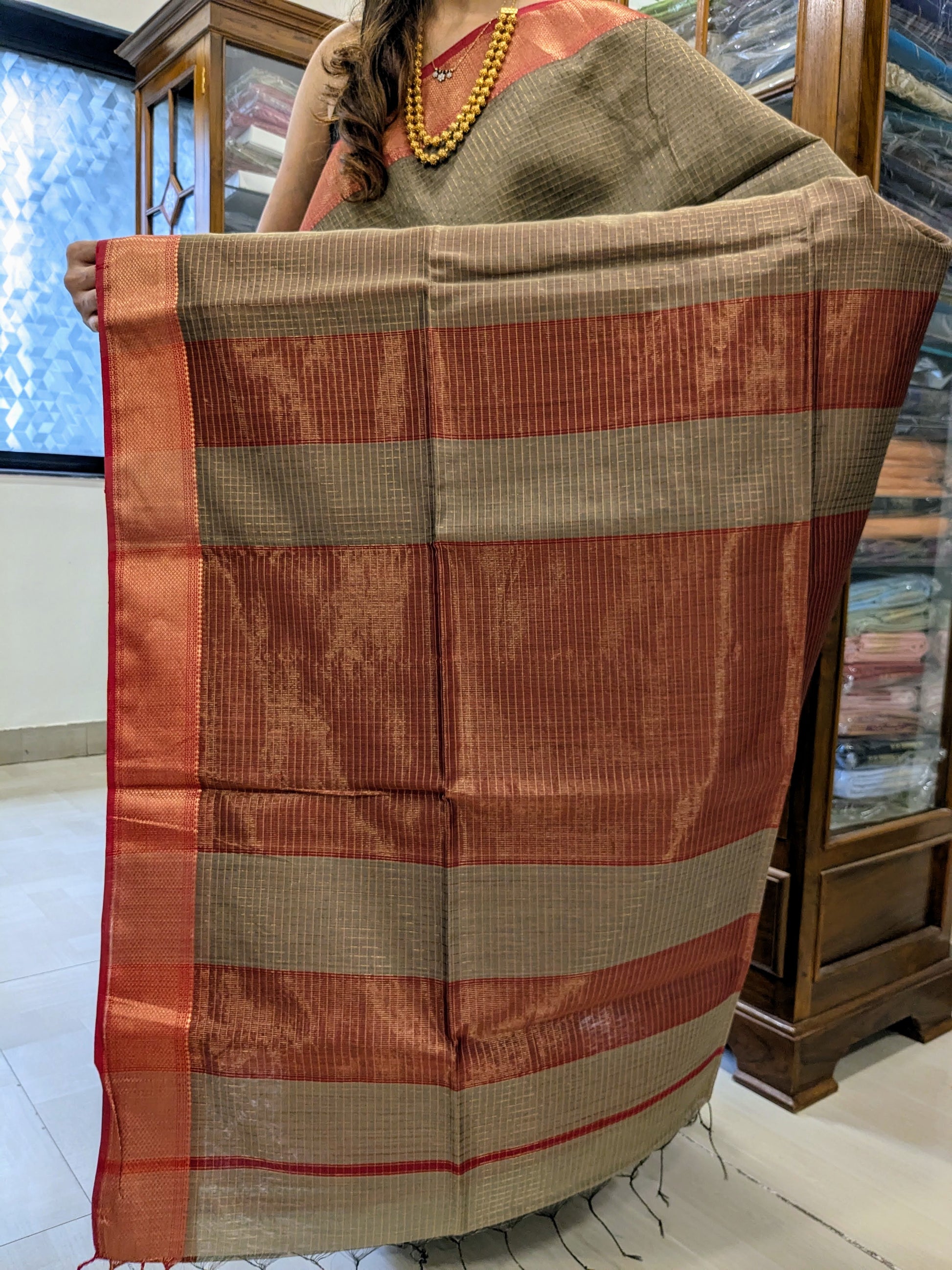 Detailed image of zari-checked pallu with fine gold threadwork in timeless Maheshwari style. 