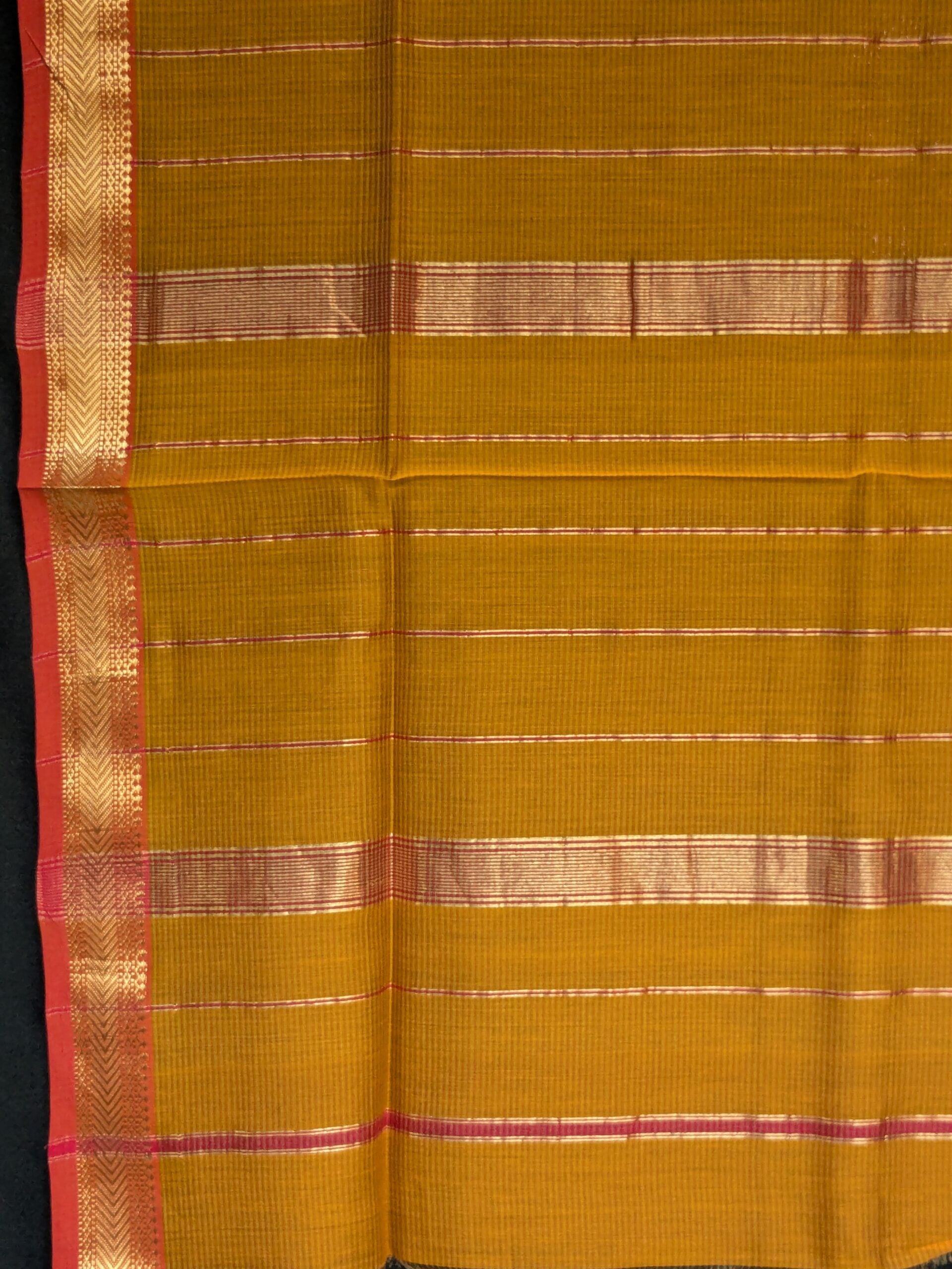 Detailed image of zari-lined pallu with lustrous golden stripes woven in classic Maheshwari style. 