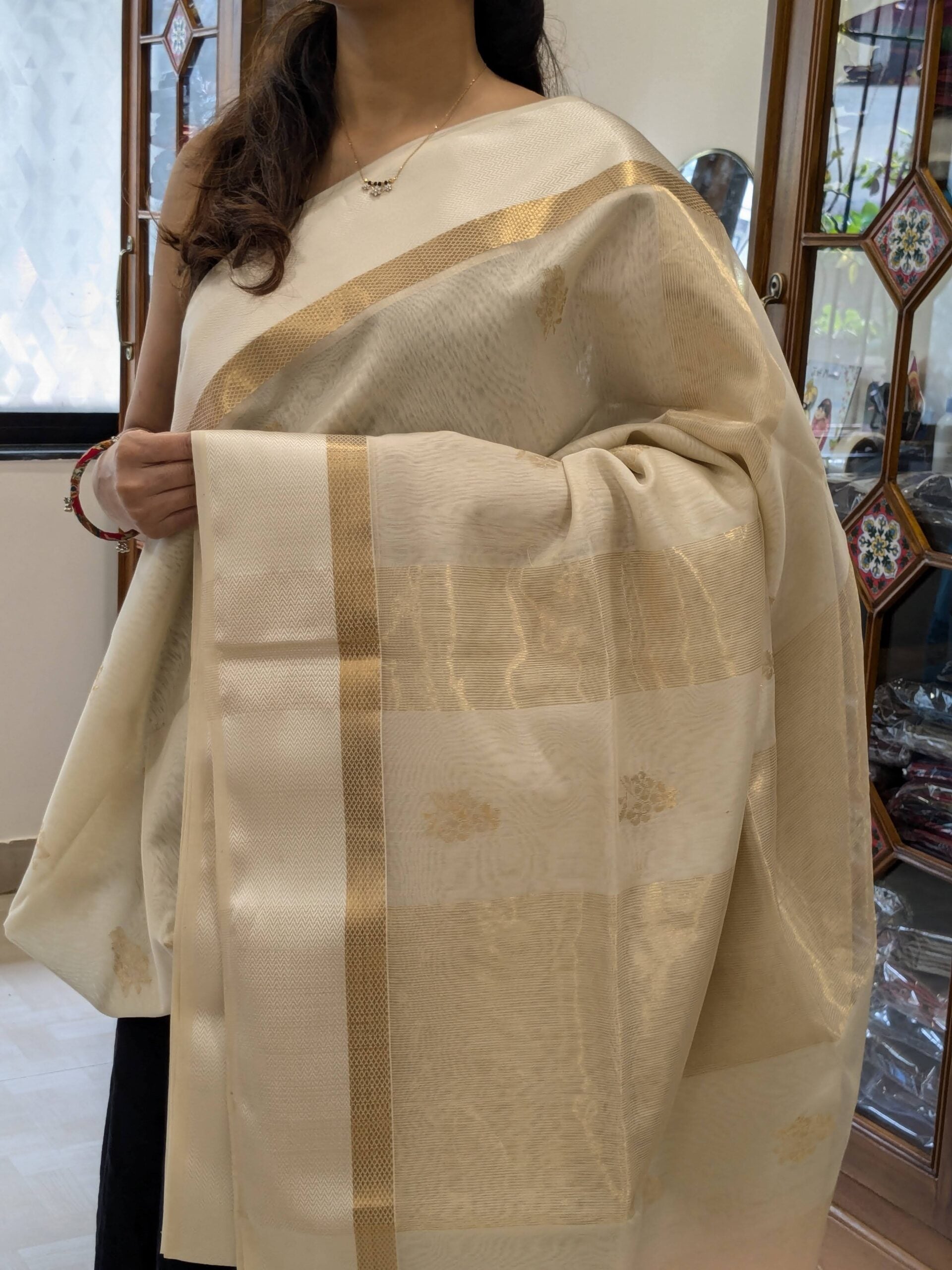 Close-up of white Maheshwari silk cotton saree with floral motifs, white resham border