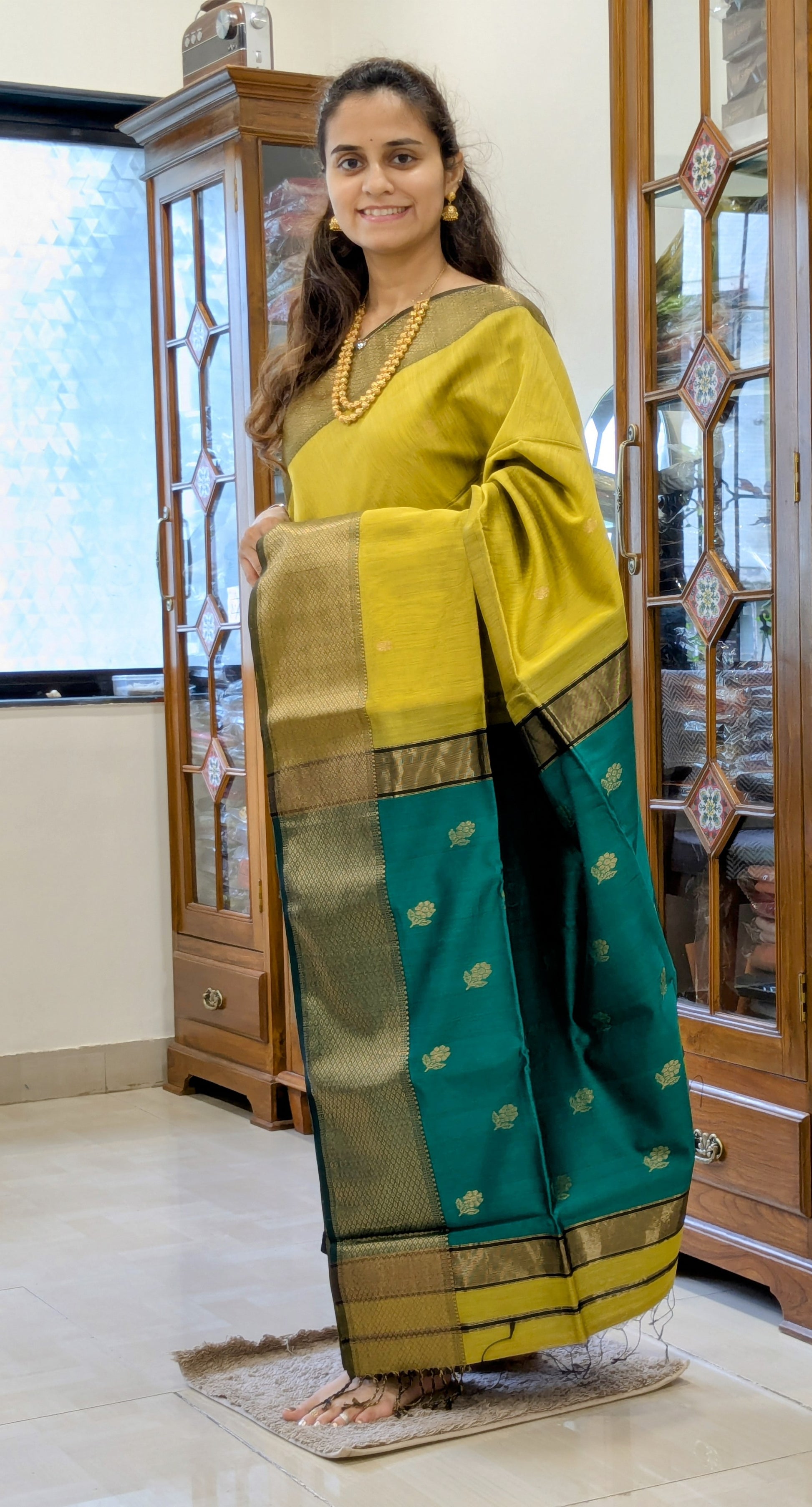 Full front view of festive mehendi green Maheshwari saree featuring delicate floral design and vibrant green accents.