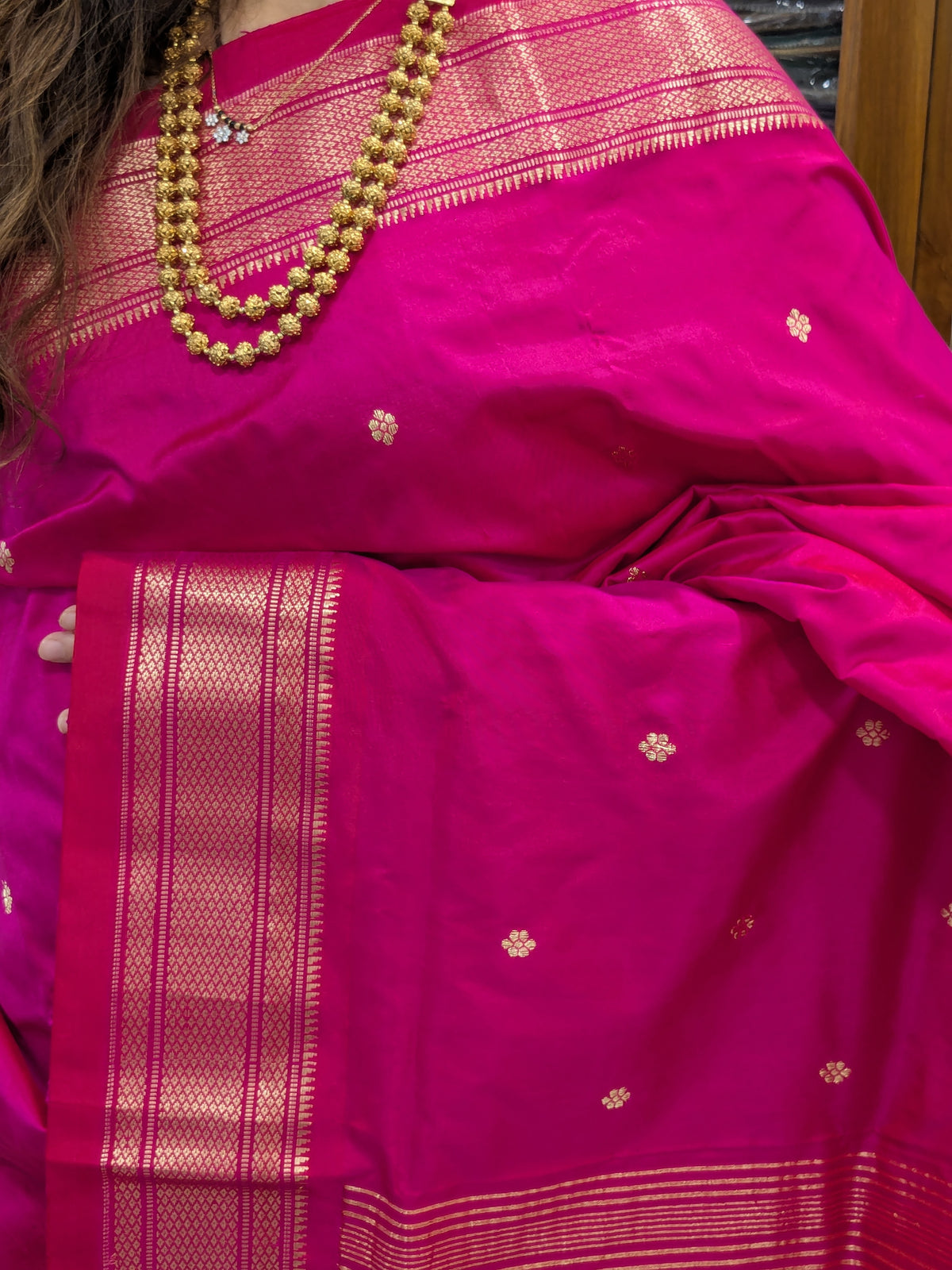 Close-up of hot pink Paithani saree in 100% pure silk with intricate flower motifs.