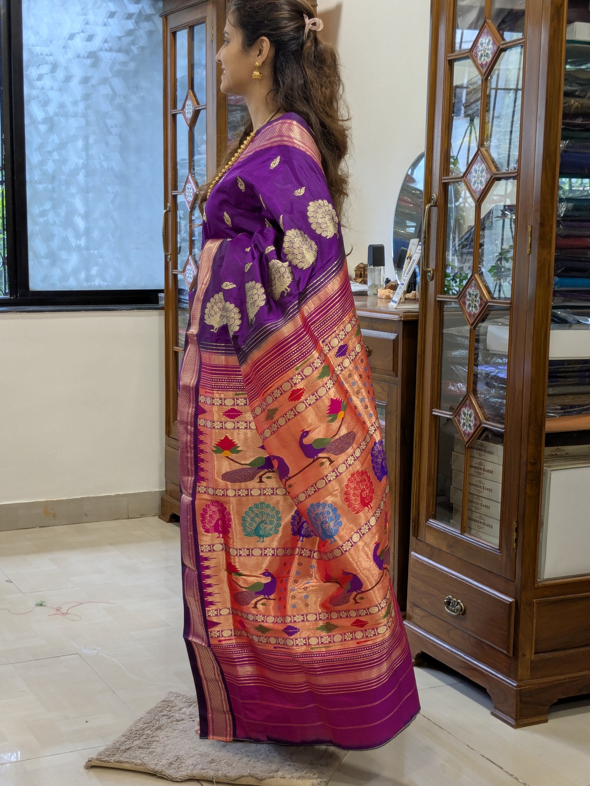 Side view highlighting soft drape and sheen of the silk fabric with peacock motifs.