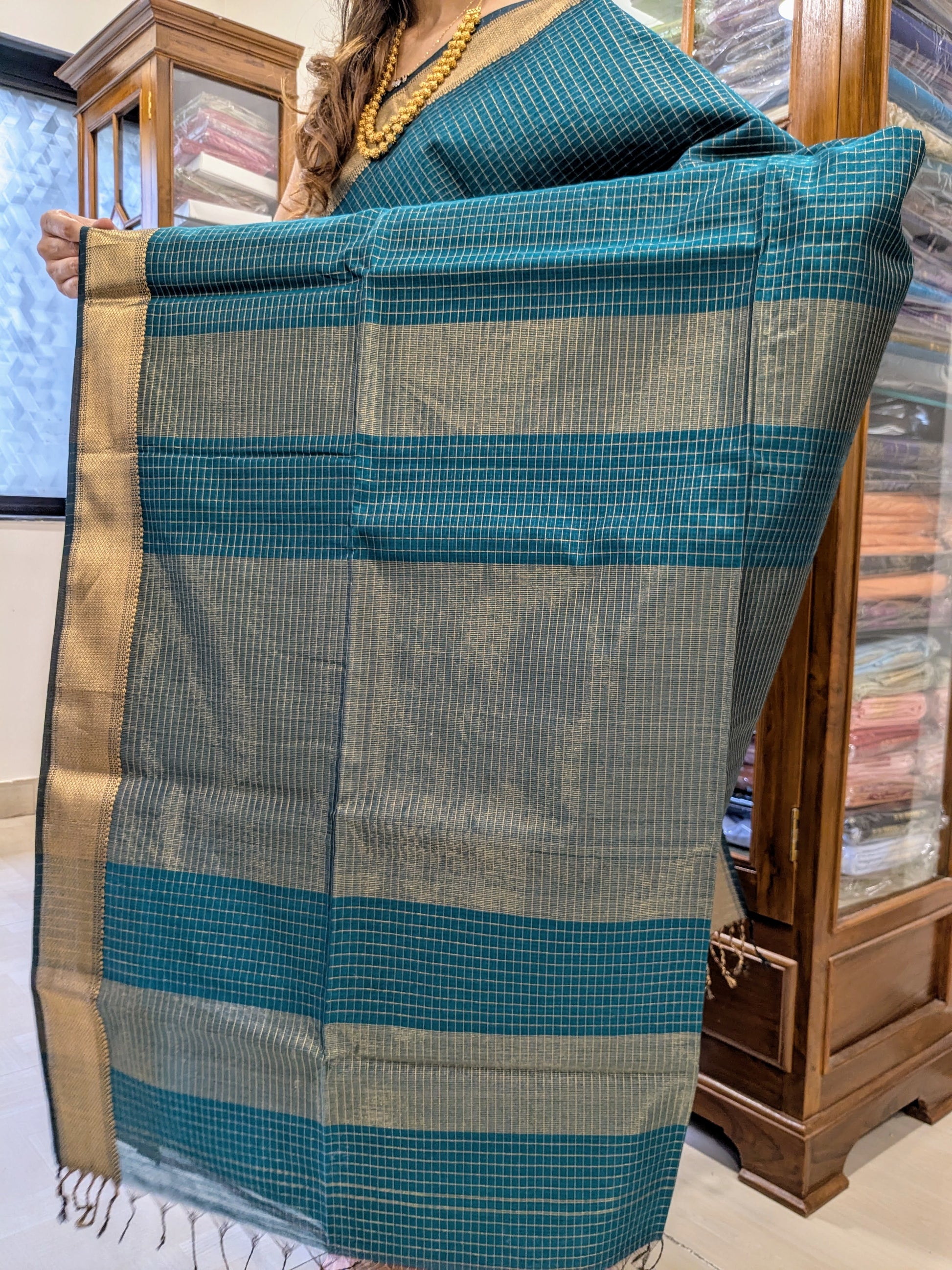 Detailed image of zari-checked pallu with intricate gold weave in classic Maheshwari style.