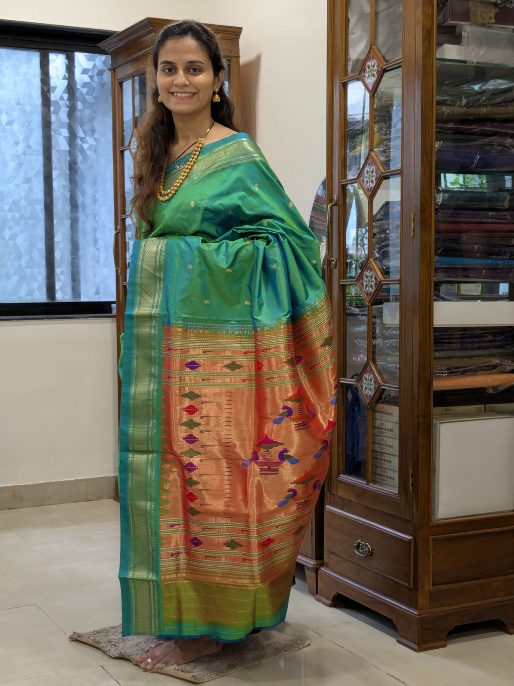 Full front view of the saree draped to showcase its bridal elegance and rich teal hue.