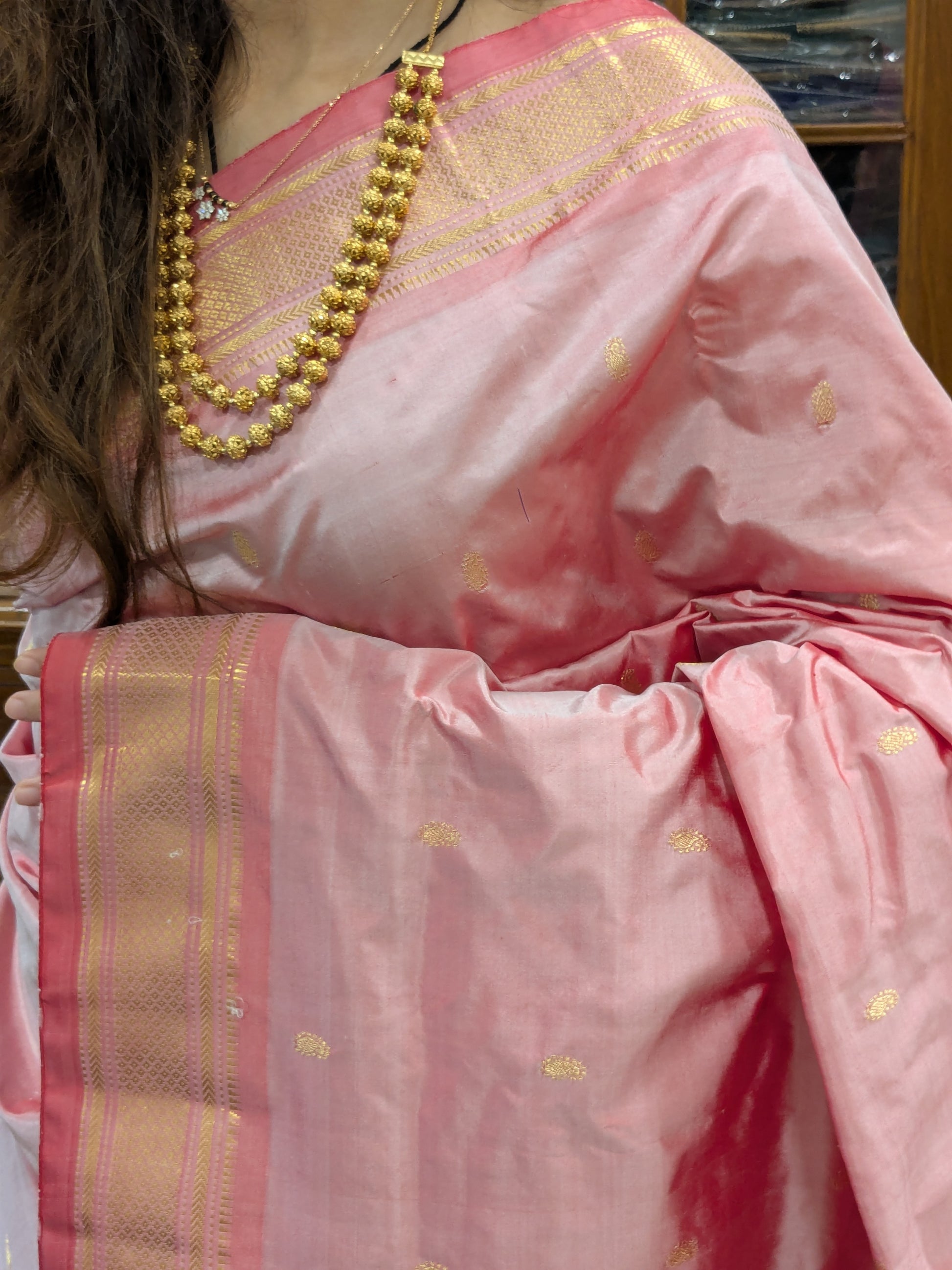 Close-up of onion pink pure silk Paithani saree with intricate koyri motifs and handwoven finesse.