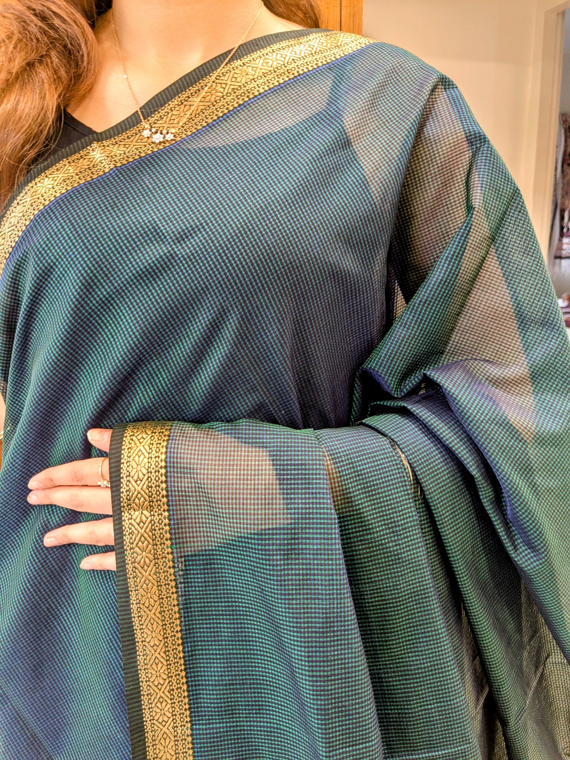 Close-up of bottle green Maheshwari saree with small checks, vintage pallu transition