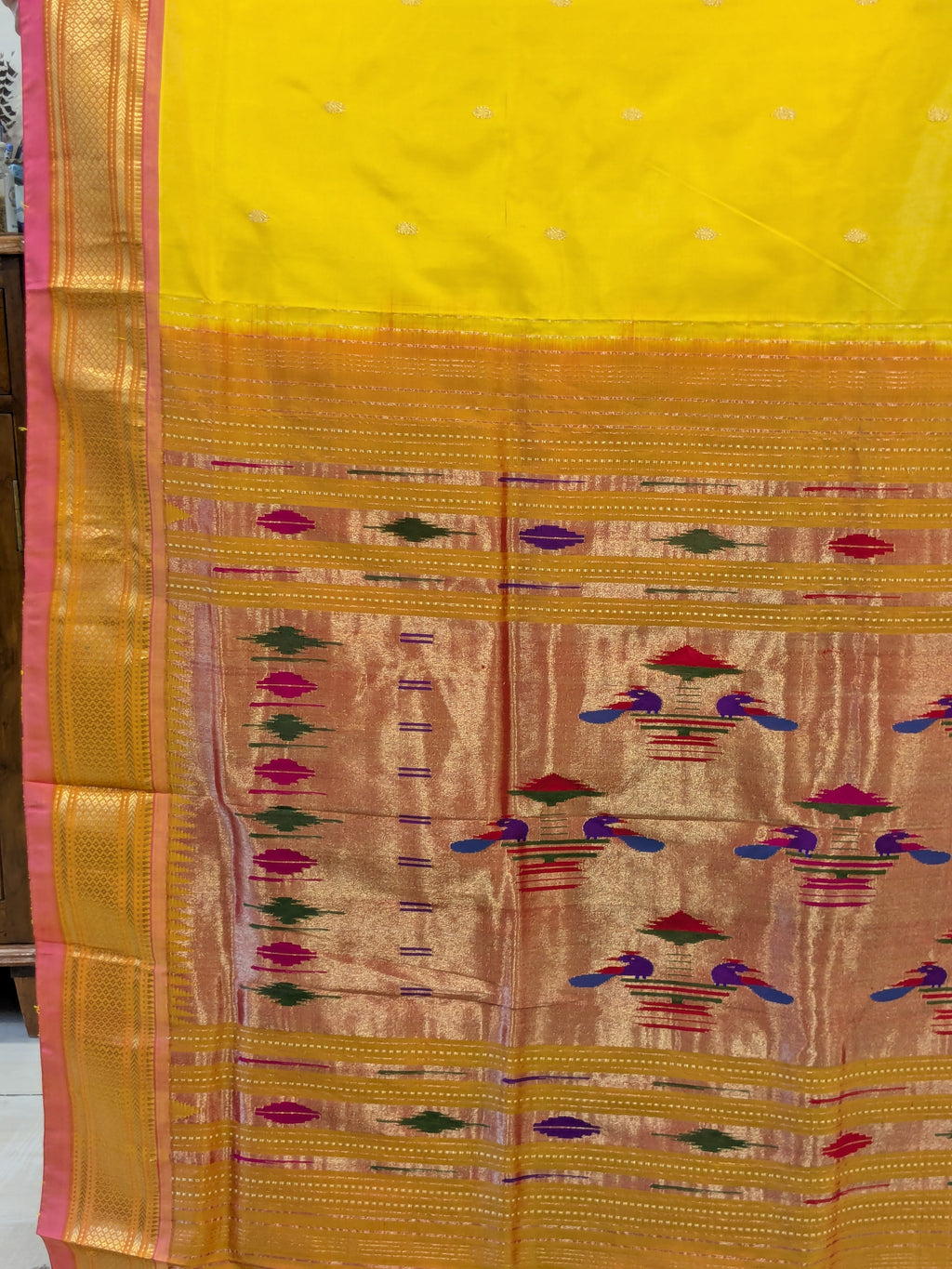 Detailed pallu with vibrant handwoven peacocks and traditional artistry.