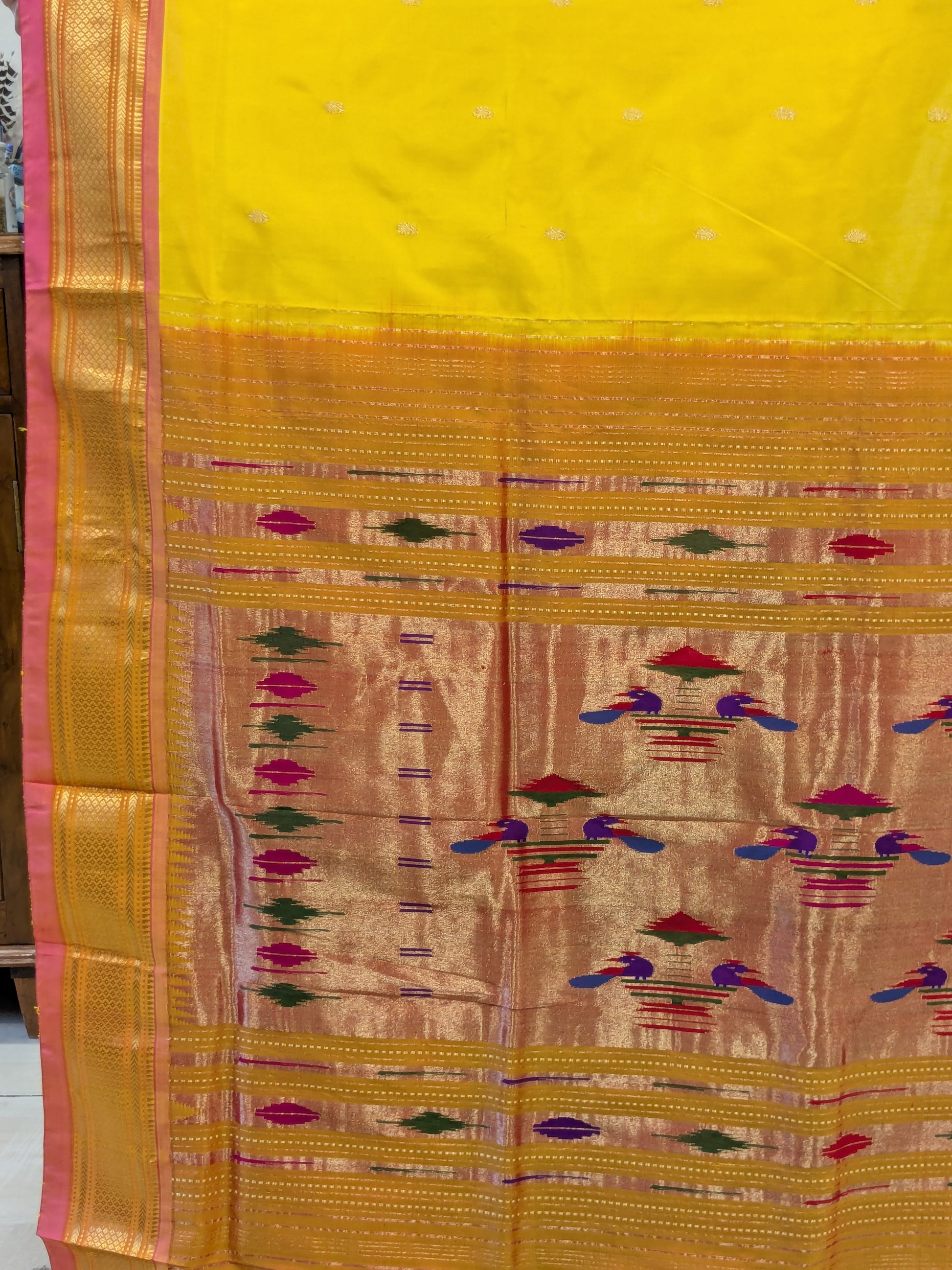 Detailed pallu with vibrant handwoven peacocks and traditional artistry.