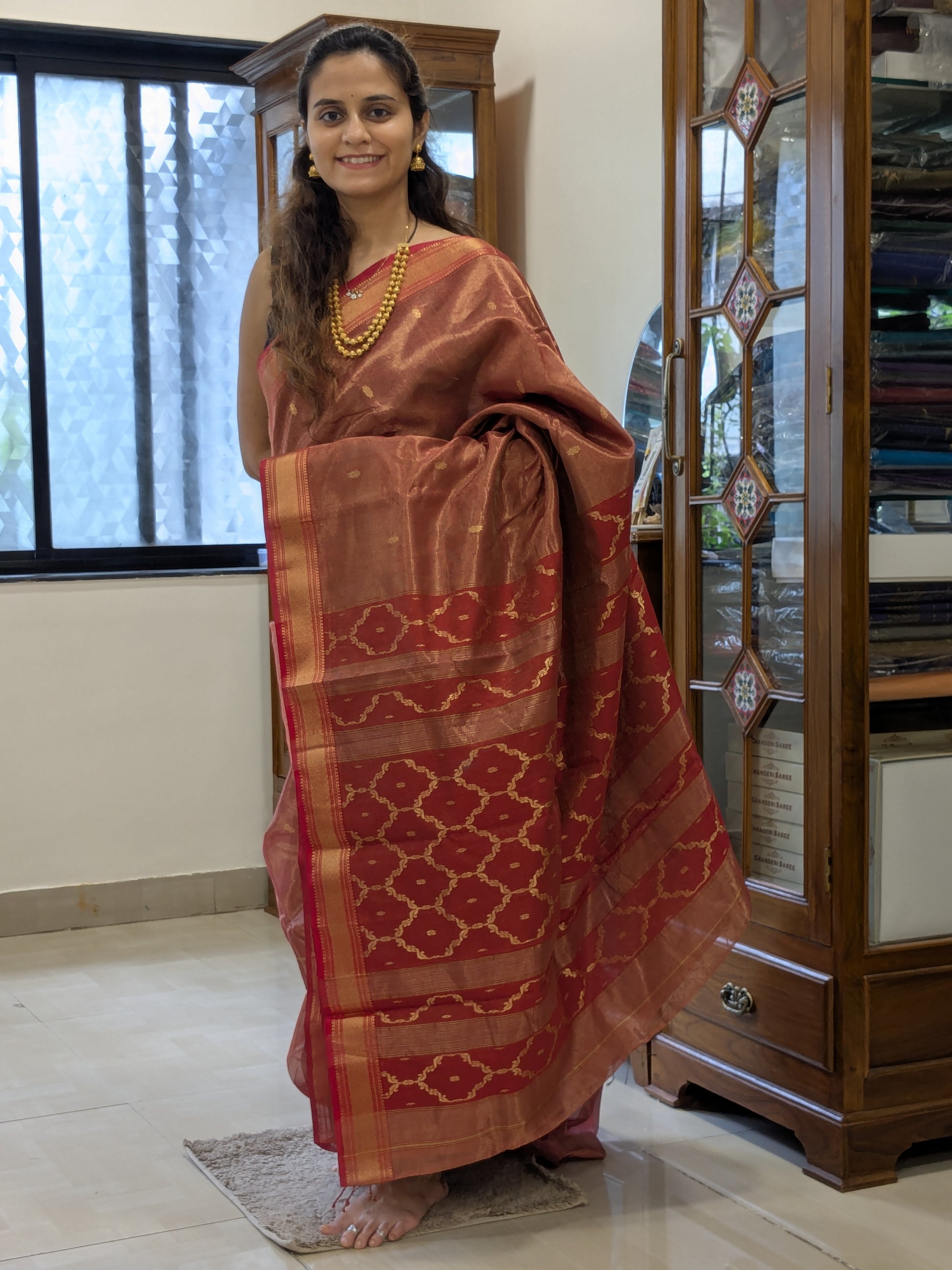 Full front view of Tomato Red Maheshwari saree highlighting silk-tissue shine and festive appeal.