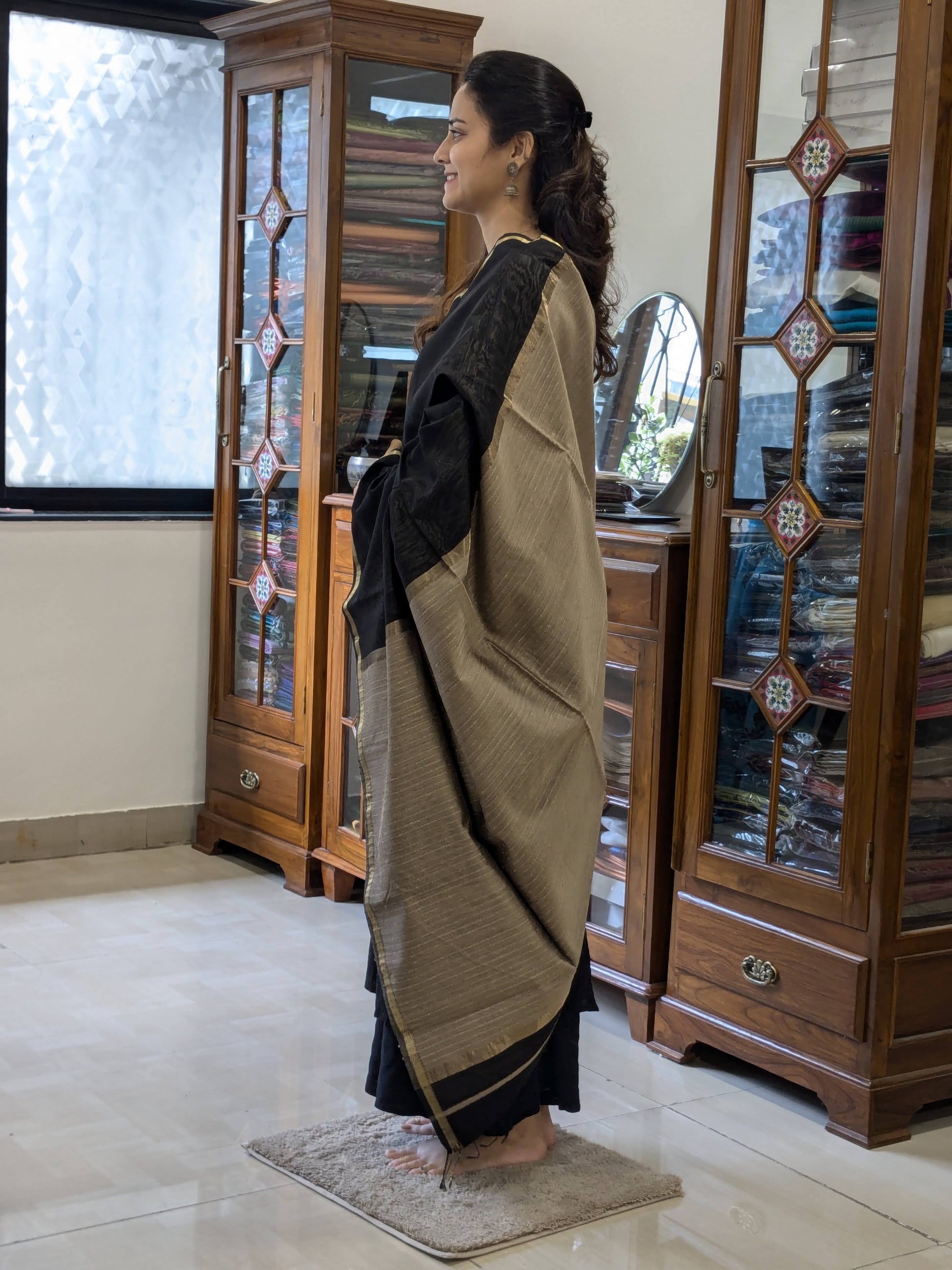 Side view of black silk-cotton saree showing fluid drape, soft weave, and understated elegance.  