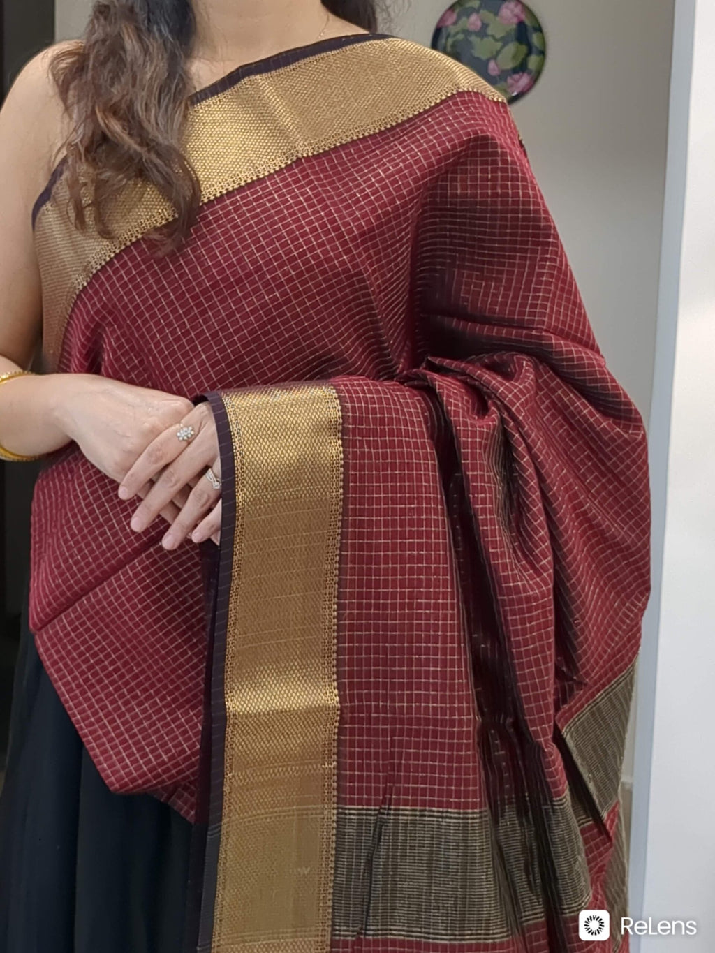 Close-up of maroon Maheshwari silk-cotton saree with zari checks, medium border
