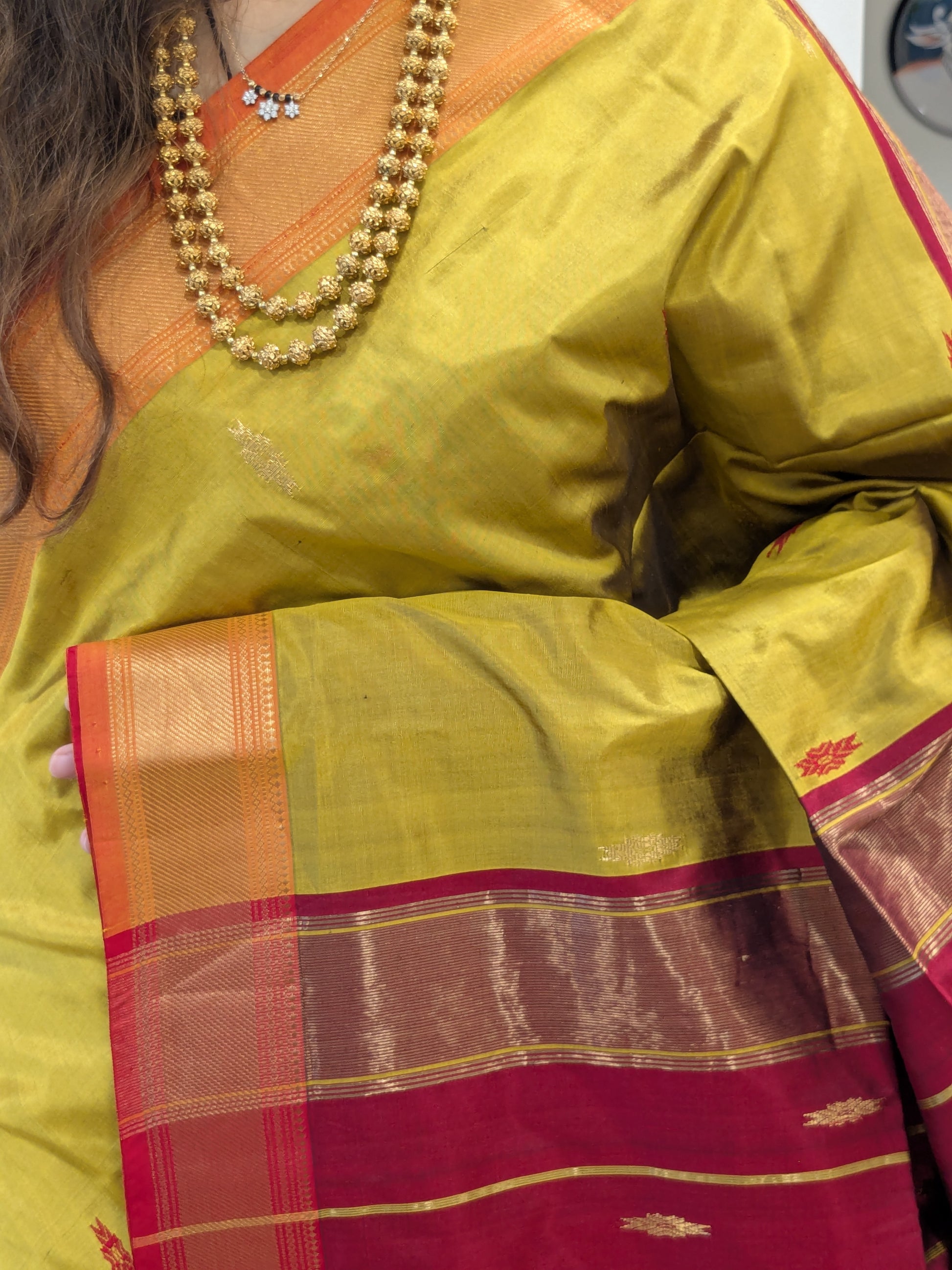 Close-up of Mehendi Green pure silk Maheshwari saree with intricate butti and small zari border.