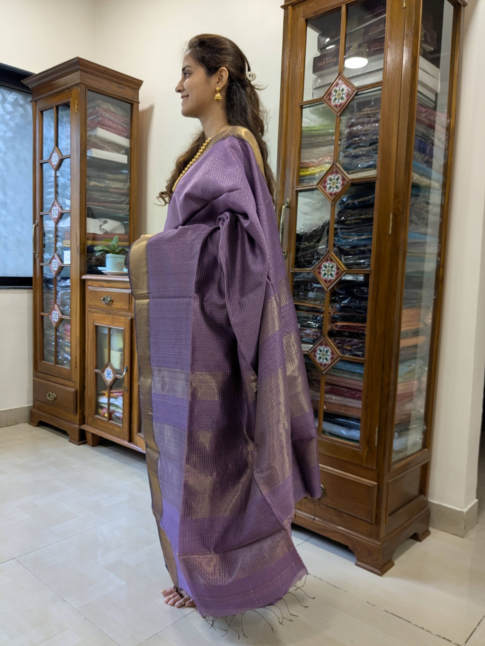 Side view of lilac saree showing soft drape, lustrous texture, and intricate traditional weaving.