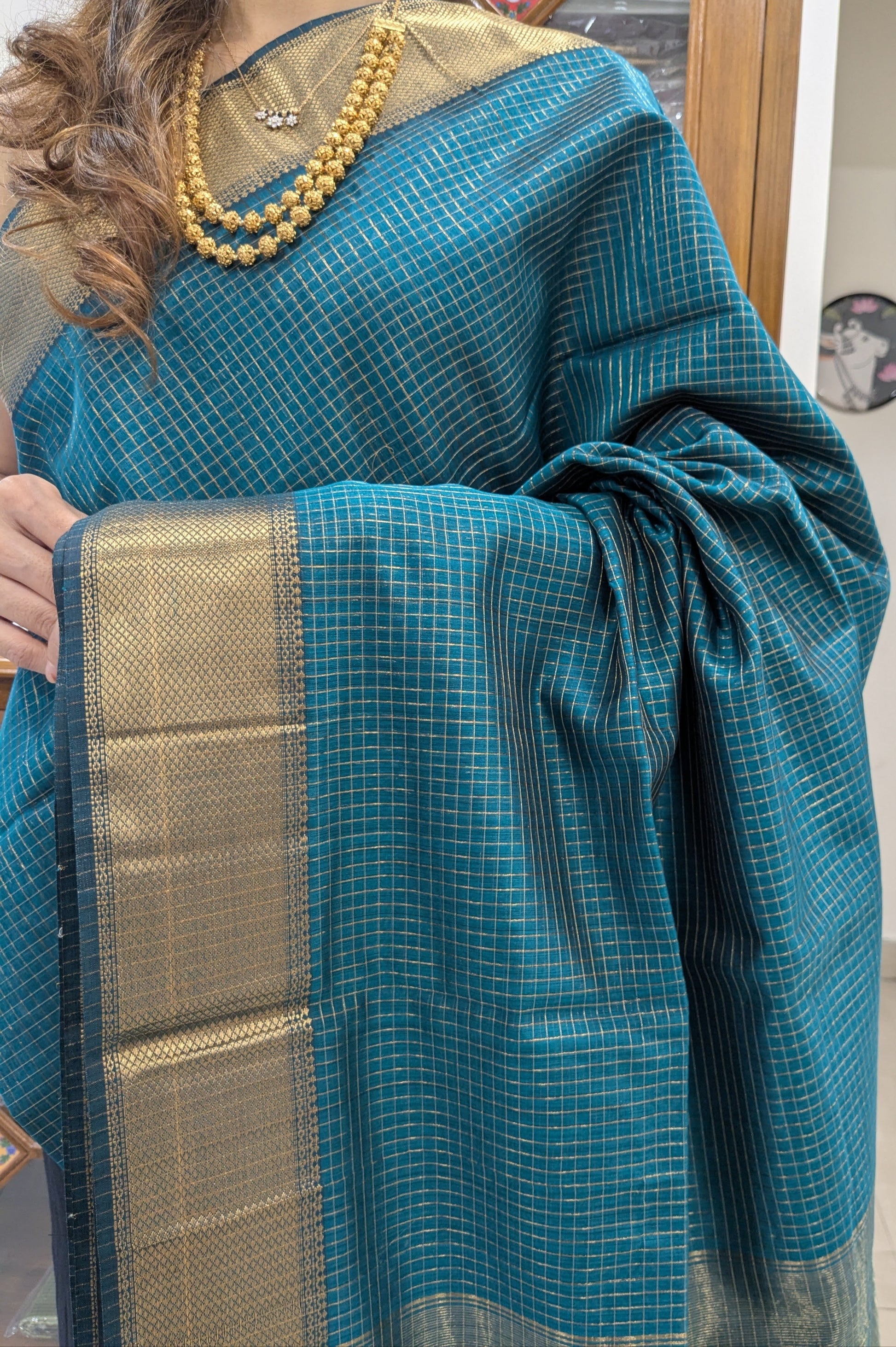 Close-up of Morpankhi Maheshwari saree with silk-cotton body, zari checks, and medium handloom border.