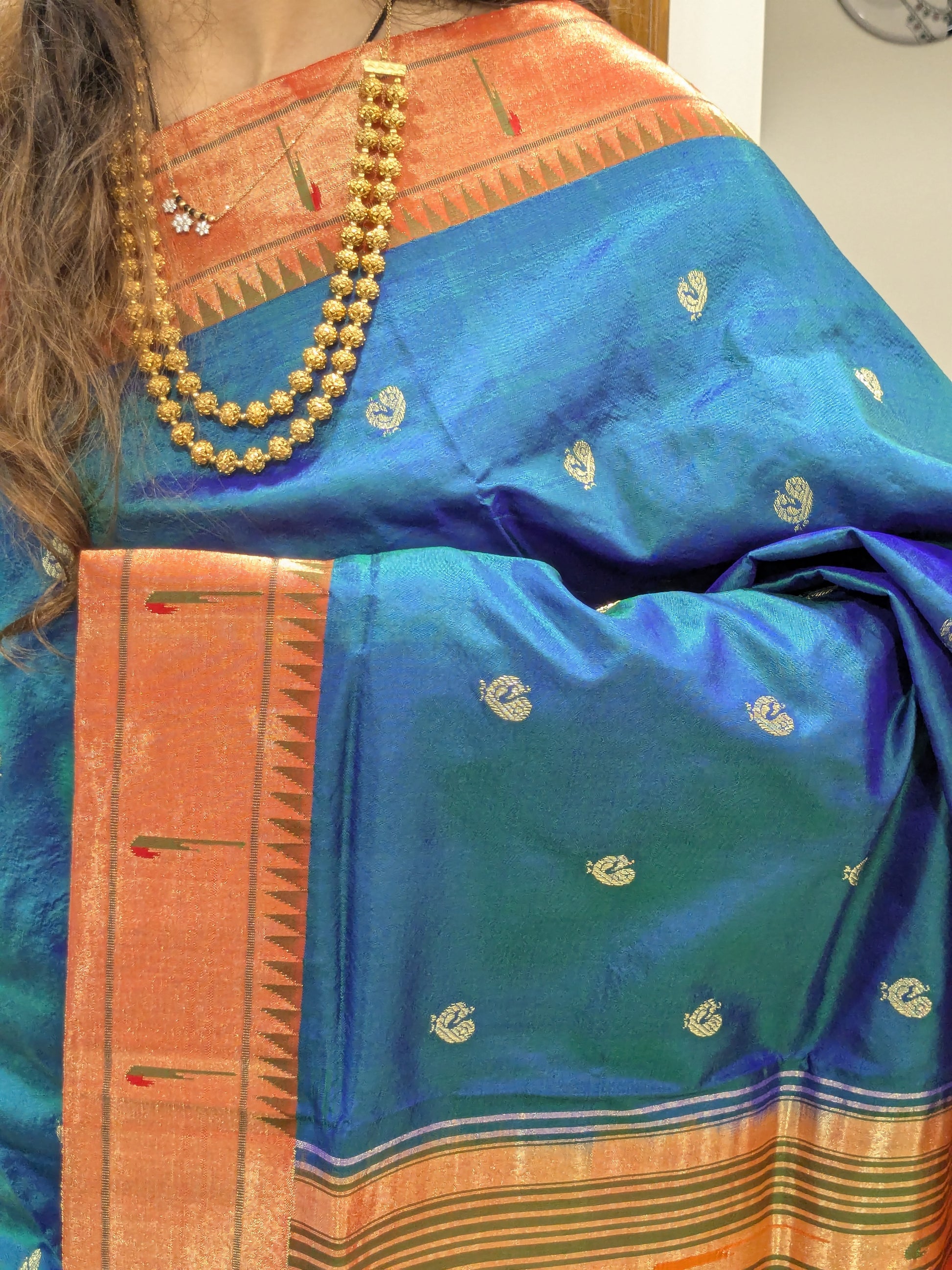 Close-up of peacock blue pure silk Paithani with full peacock butti and Muniya border.