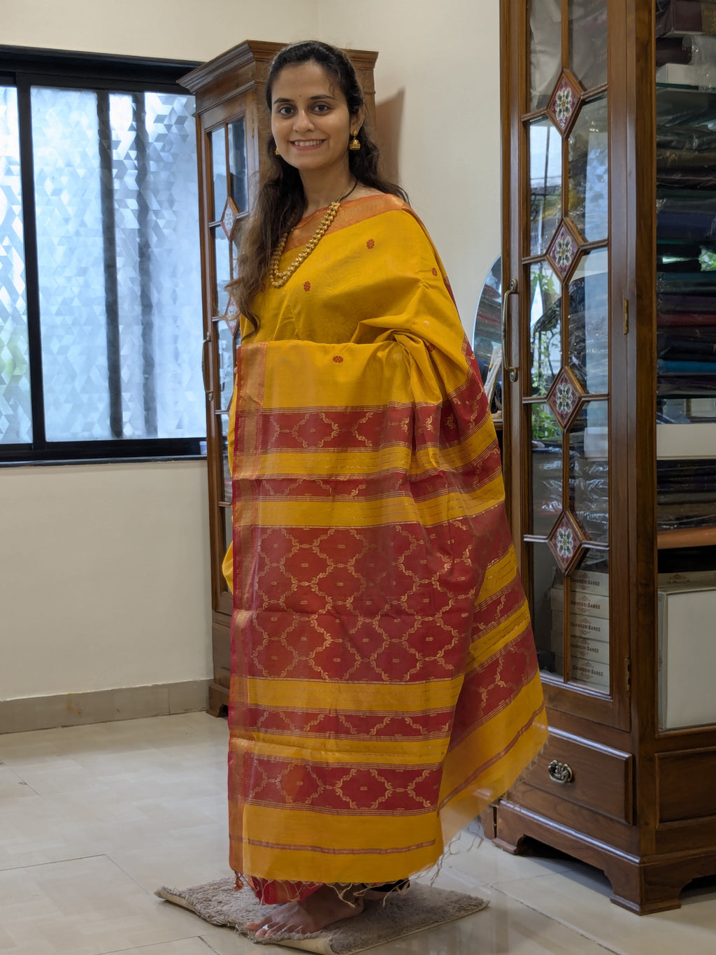 Full front view of festive yellow Maheshwari silk-tissue saree radiating elegant sheen.