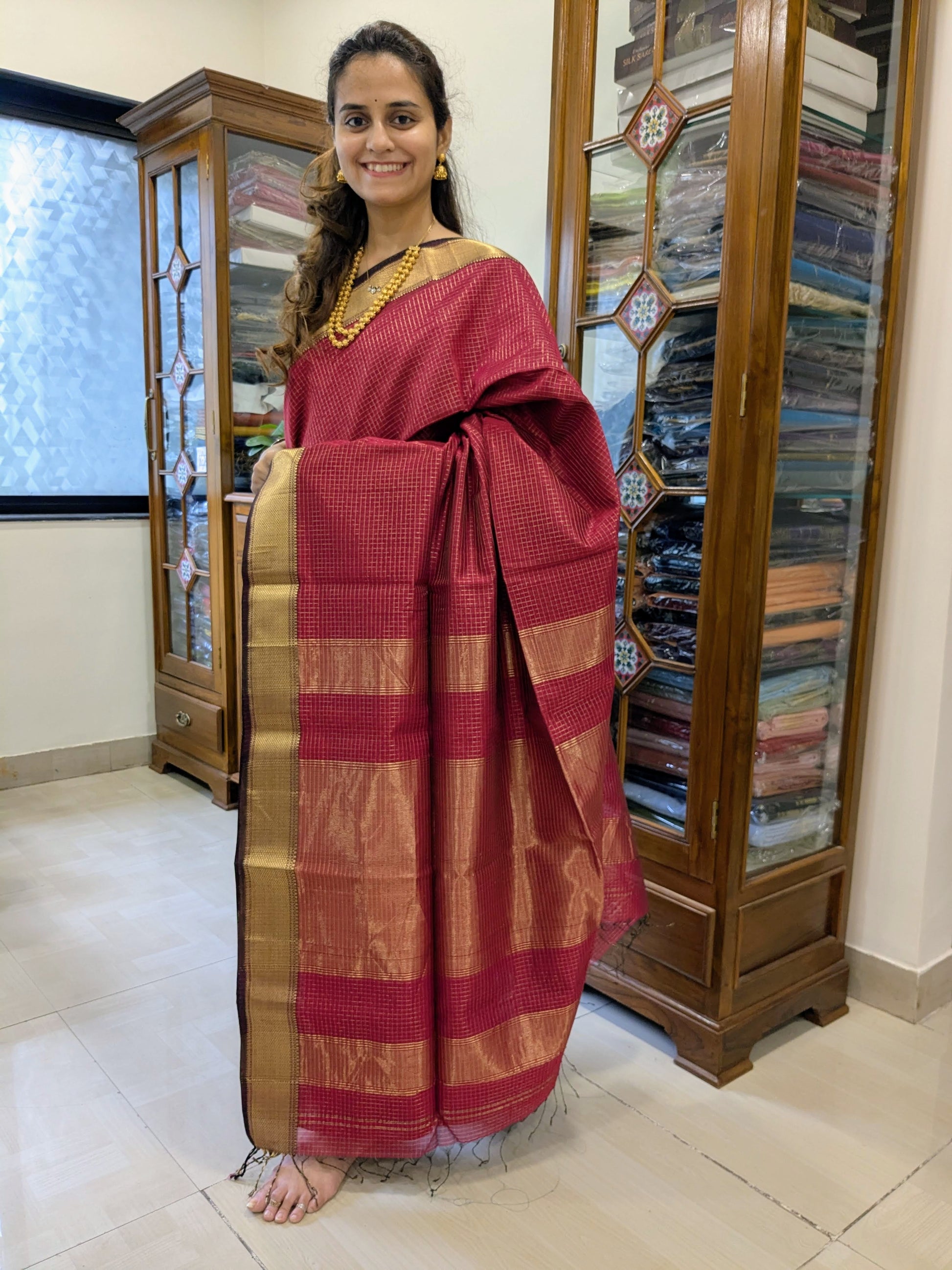 Full front view of vibrant fresh red handloom Maheshwari saree featuring golden check pattern and festive sheen.