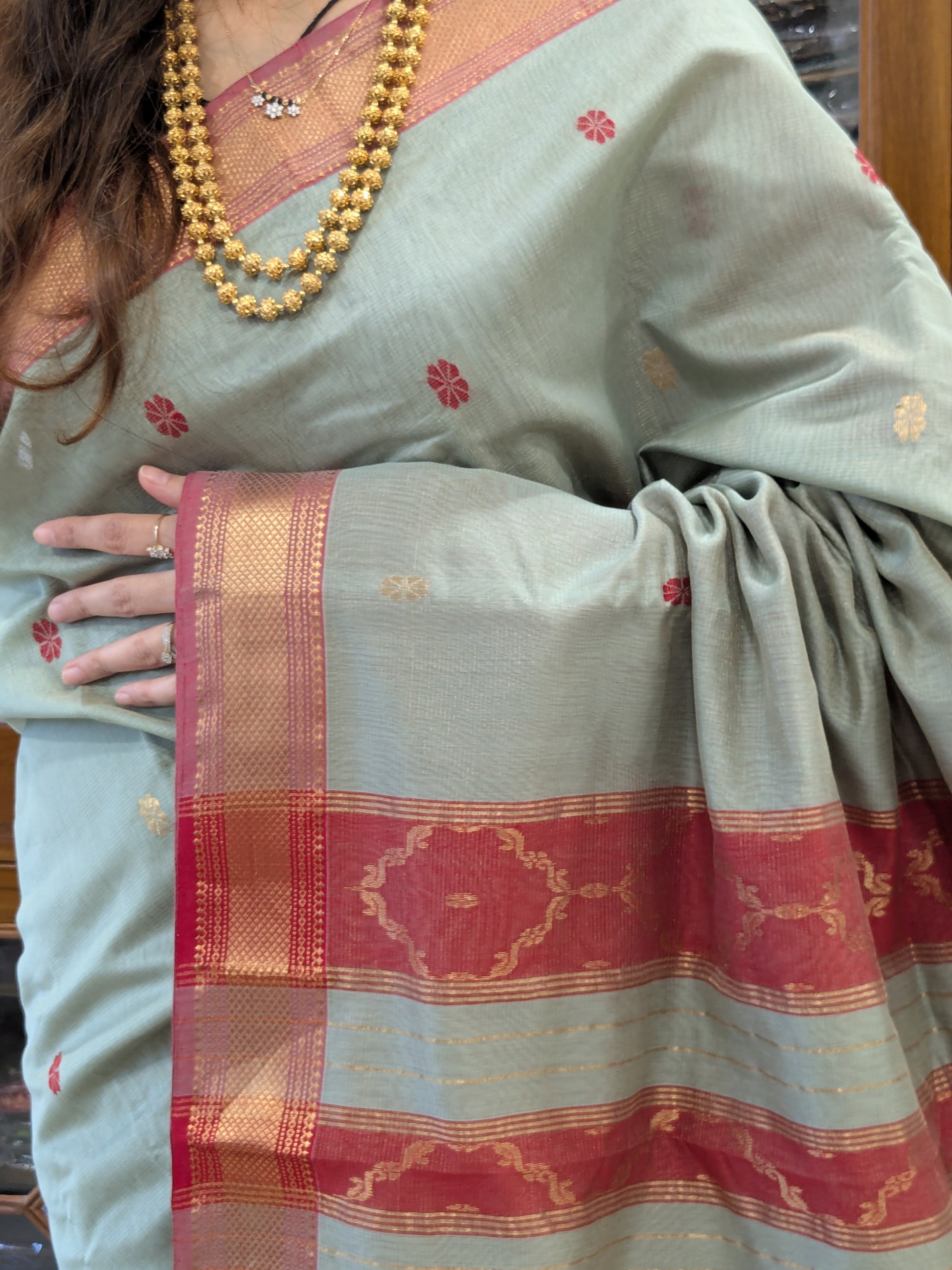 Close-up of Sea Mist silk tissue Maheshwari saree with flower butti, jaali pallu, and intricate medium border.
